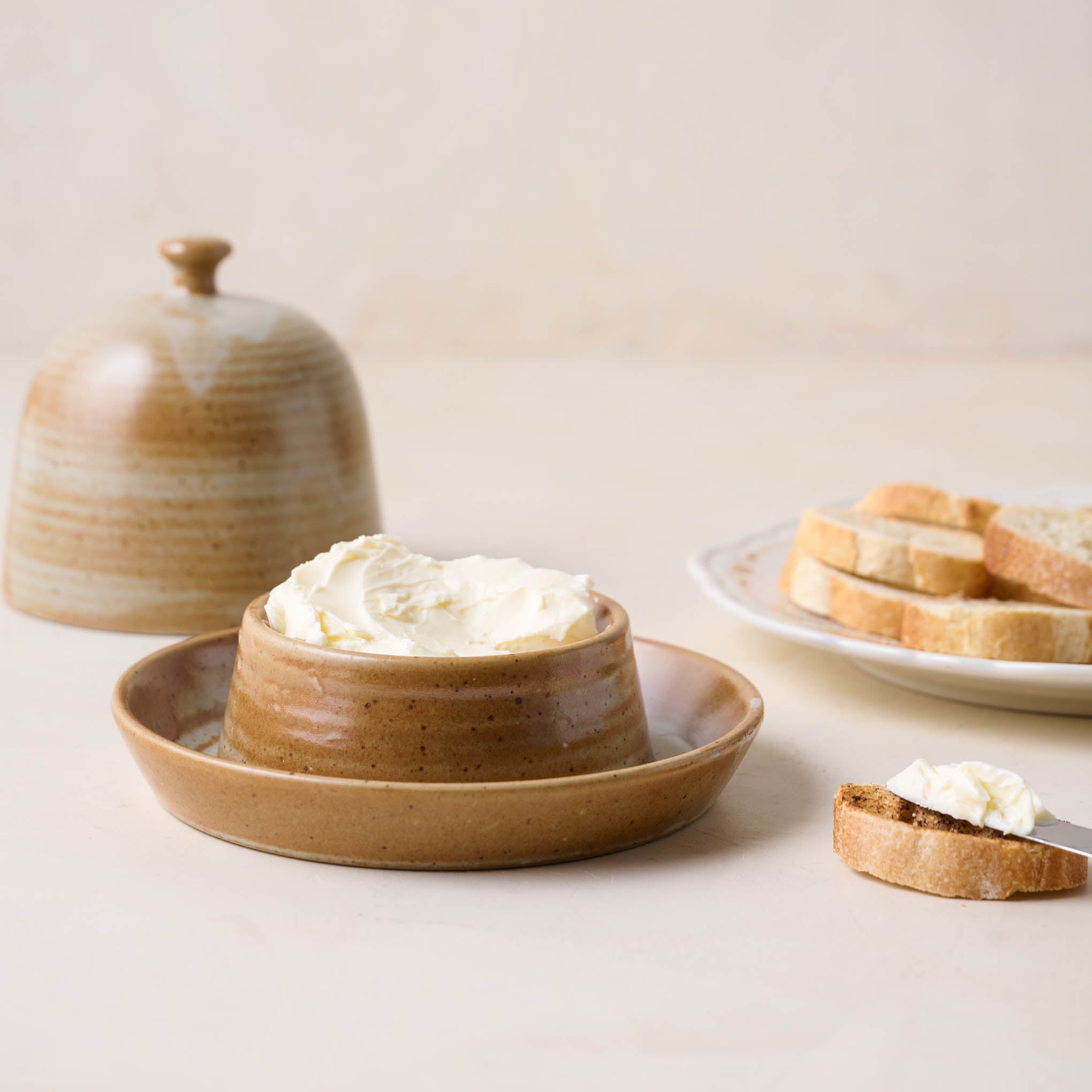 French Grey Reduction Fire Butter Dish with butter inside next to a plate of bread