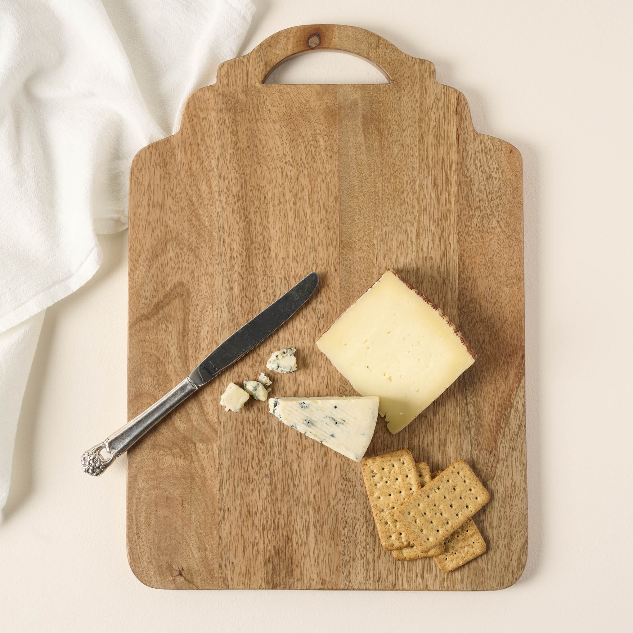 Ells Wooden Serving Board with cheese, crackers, and a butter knife on it $38.00