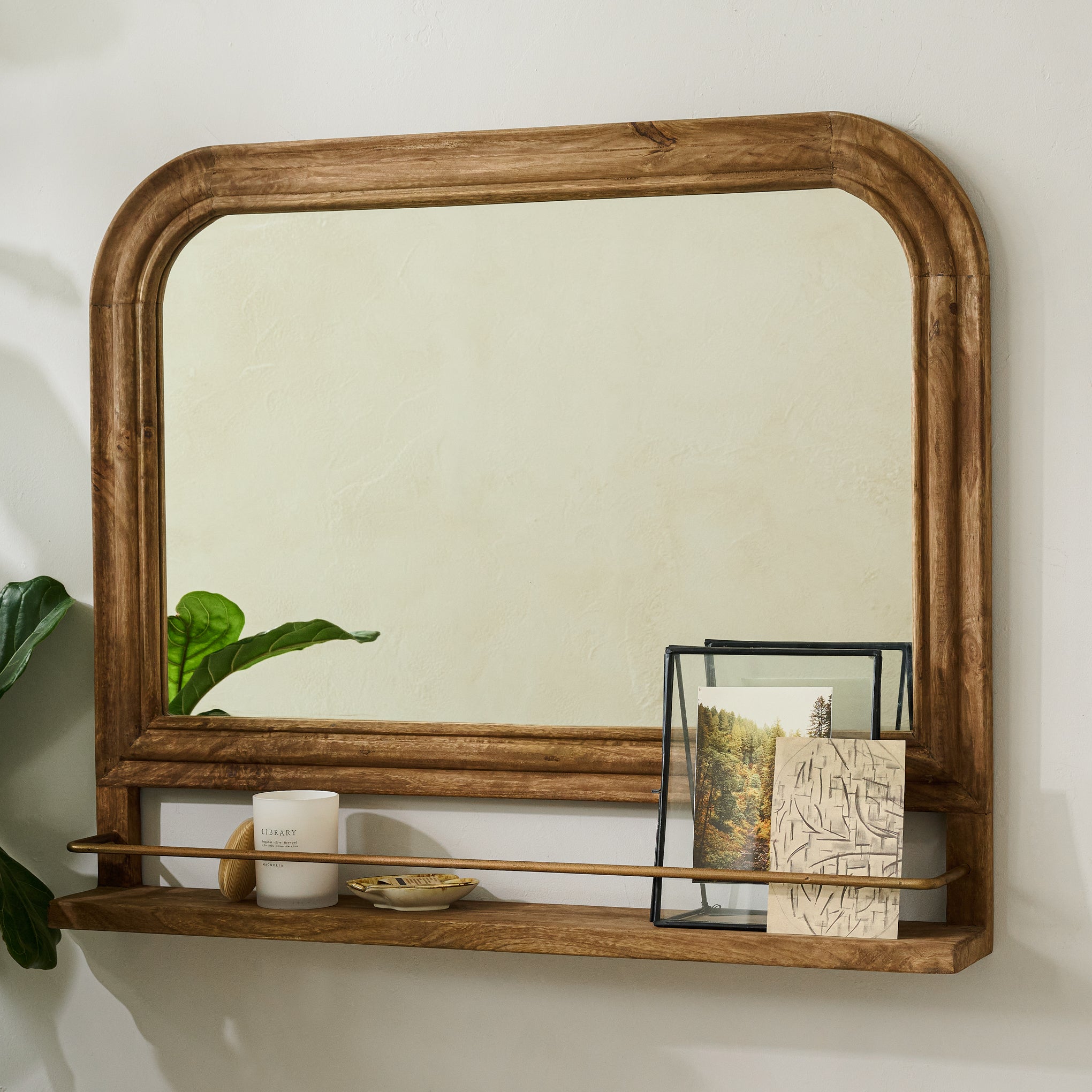 Round Top Wood Mirror with Shelf hung on a white wall