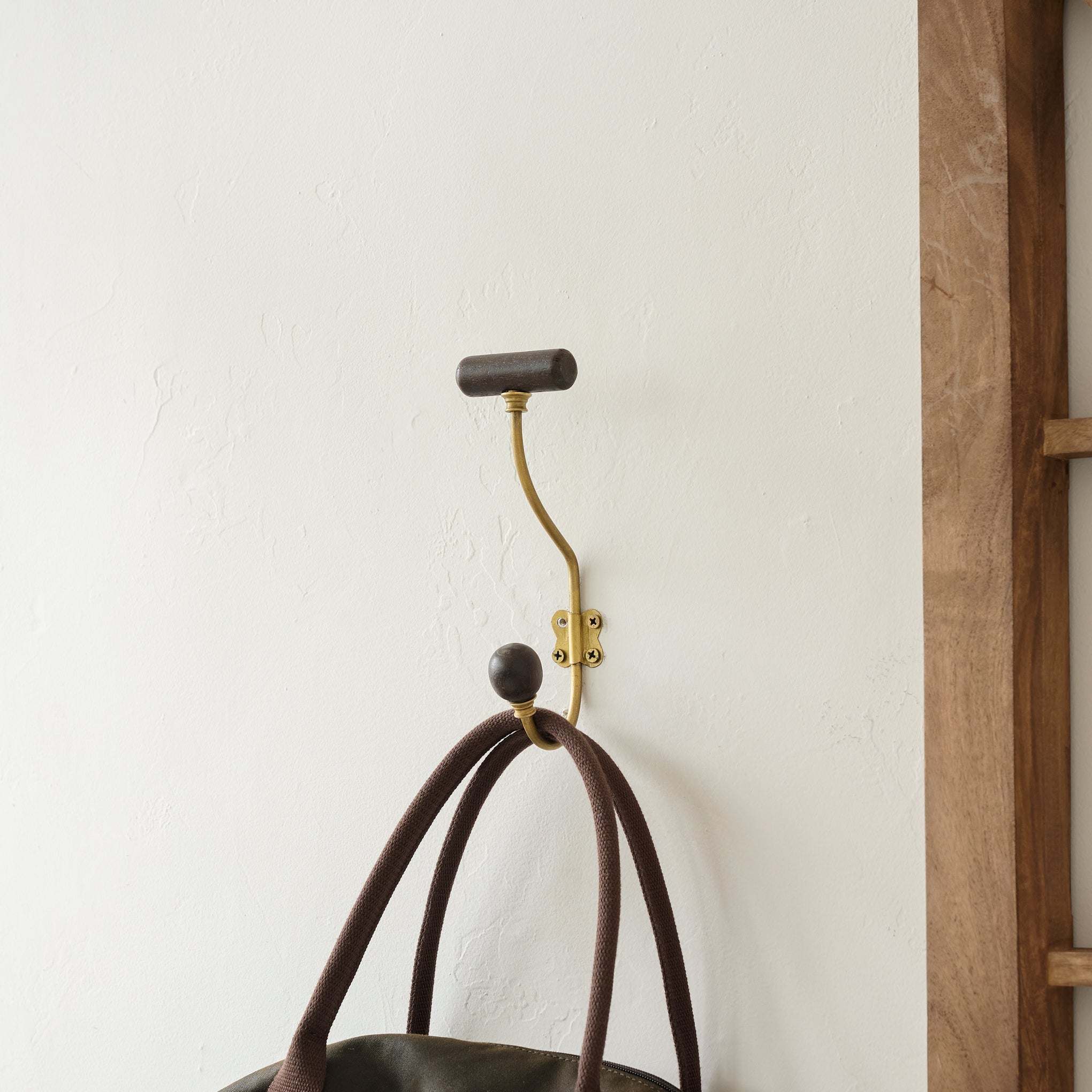 Grant Wood and Brass Single Hook on wall holding purse