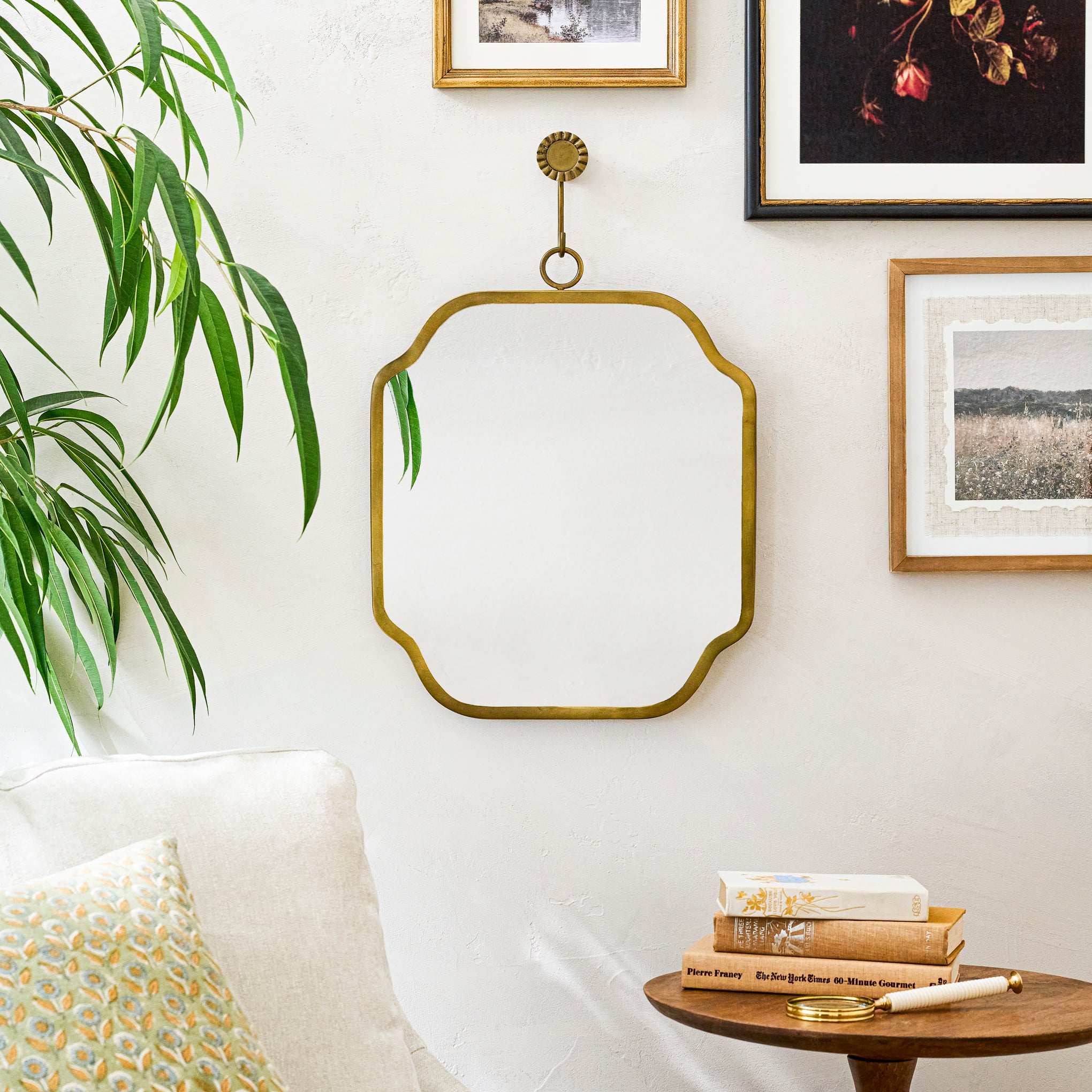 Justine Brass Hanging Mirror on a wall with art