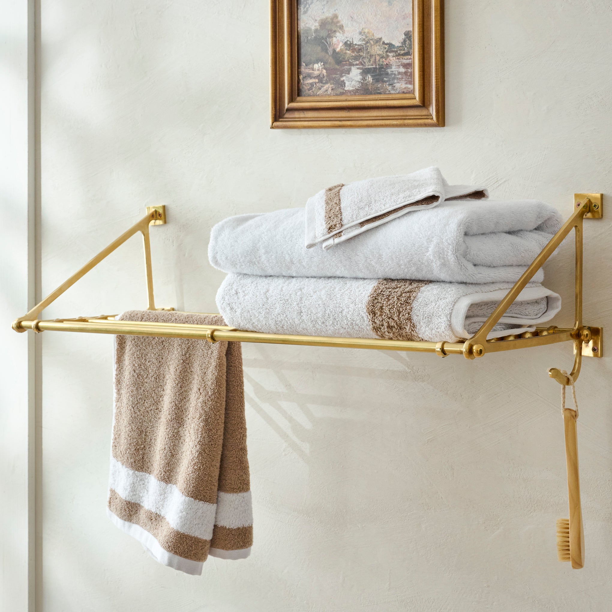 Jules Solid Brass Train Rack shown with bathroom towels