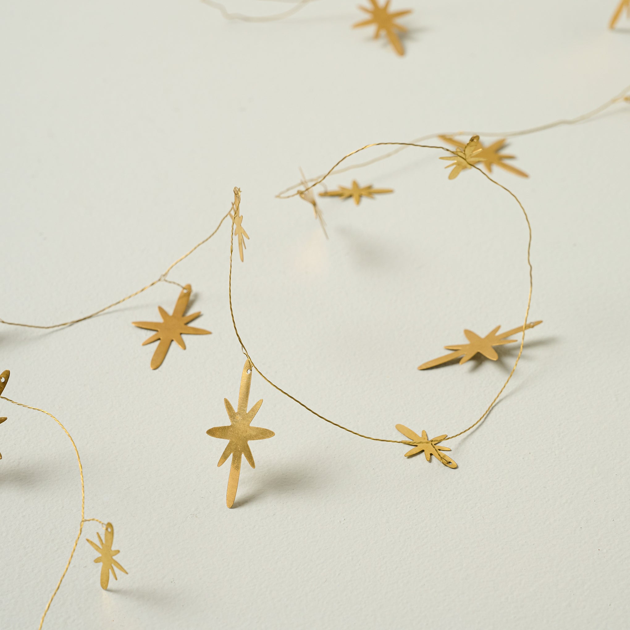 Gilded Star Garland against a beige background close up