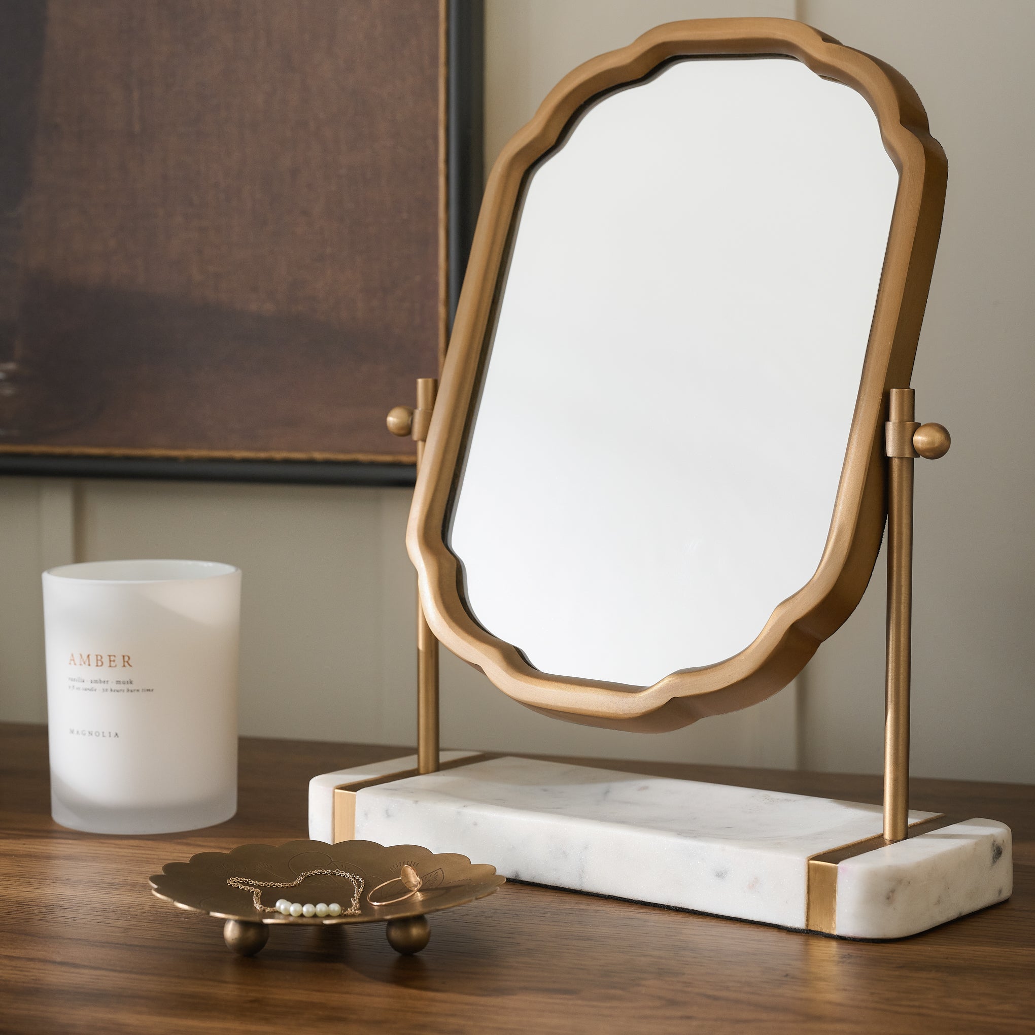 Antique Brass and Marble Vanity Mirror shown with candle and trinket tray on wood table