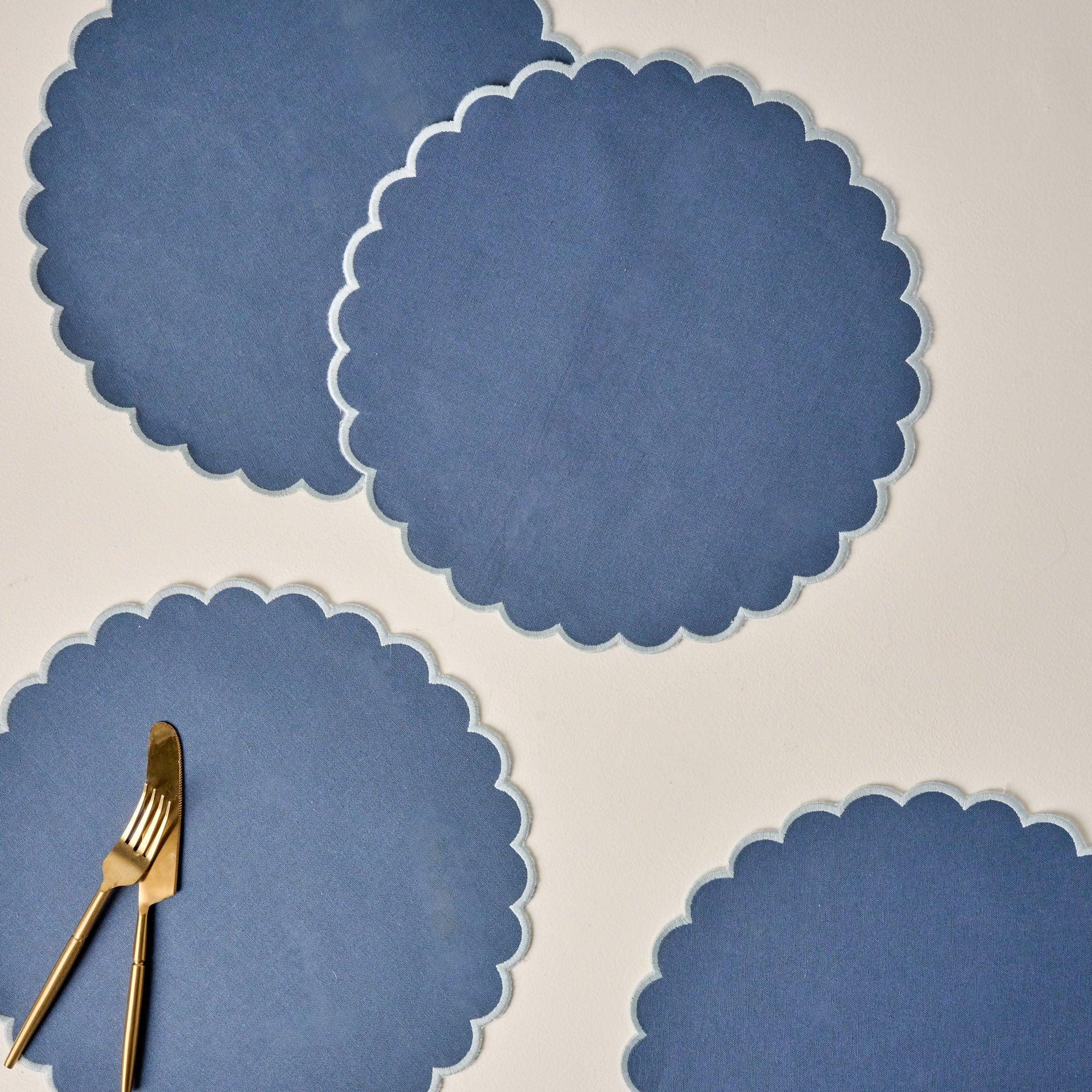 Orian Blue Scalloped Placemat Set of Four shown with utensils