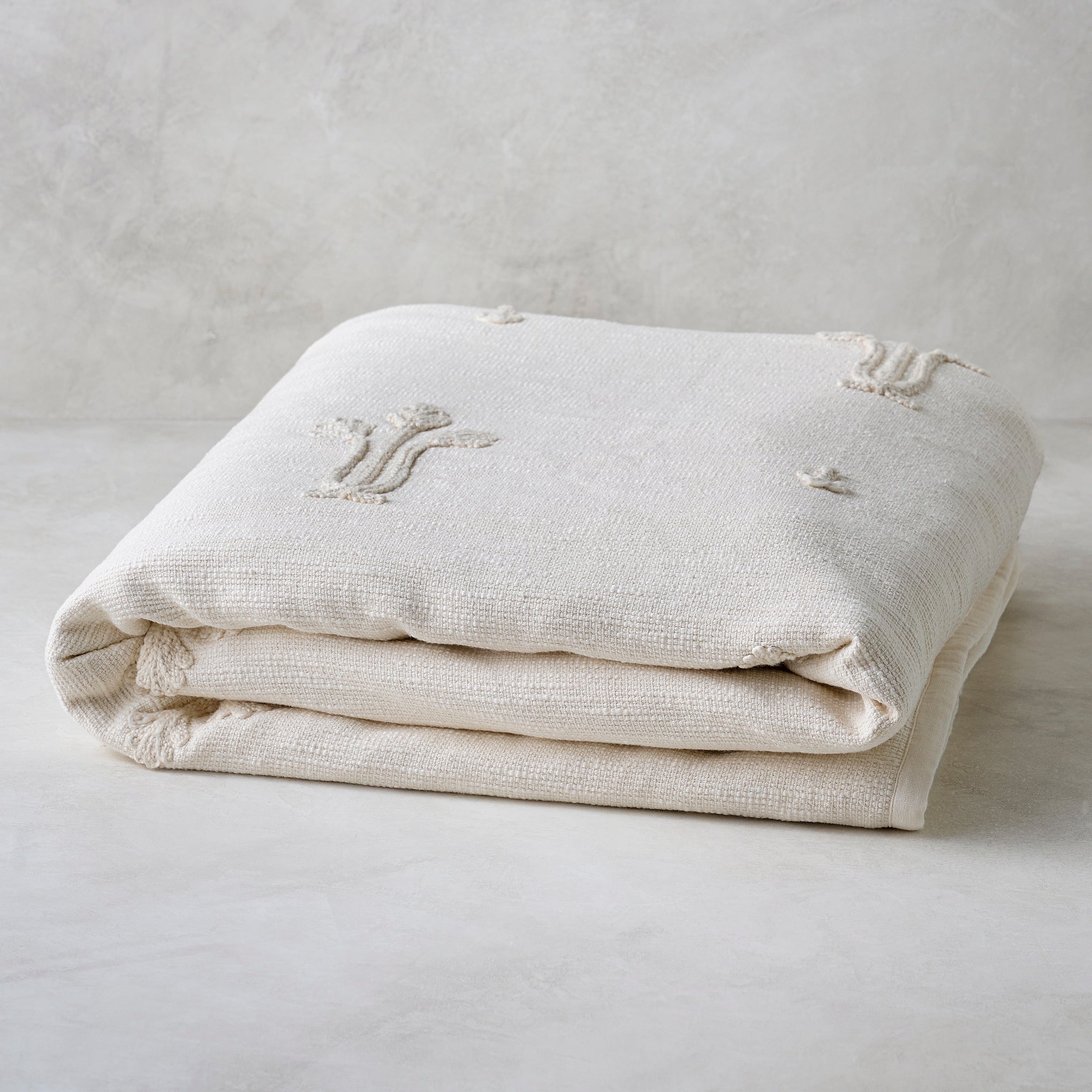 Cream Tulip Textured Coverlet shown folded Items range from $180.00 to $200.00