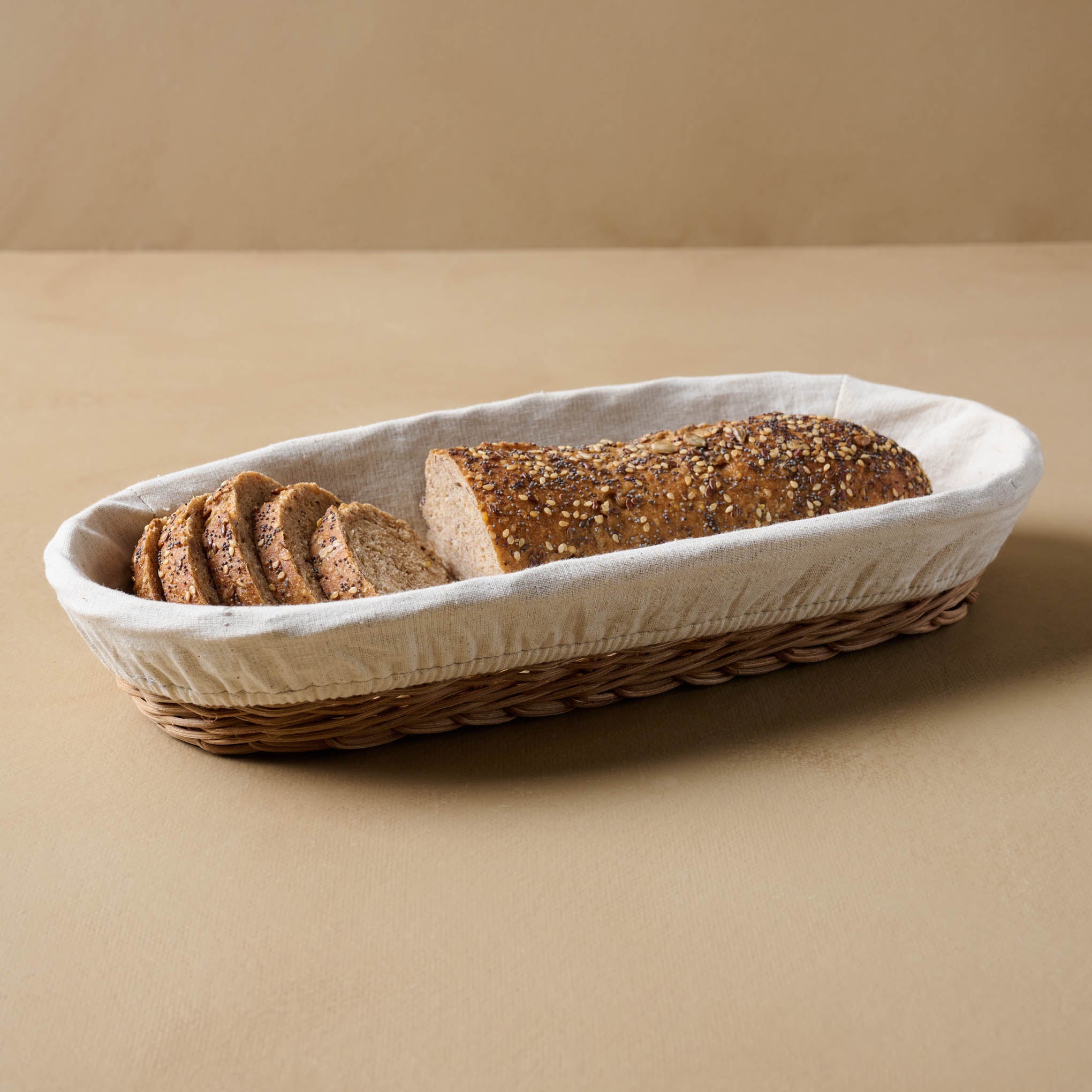 Lasata Oblong Rattan Bread Basket with a loaf of bread