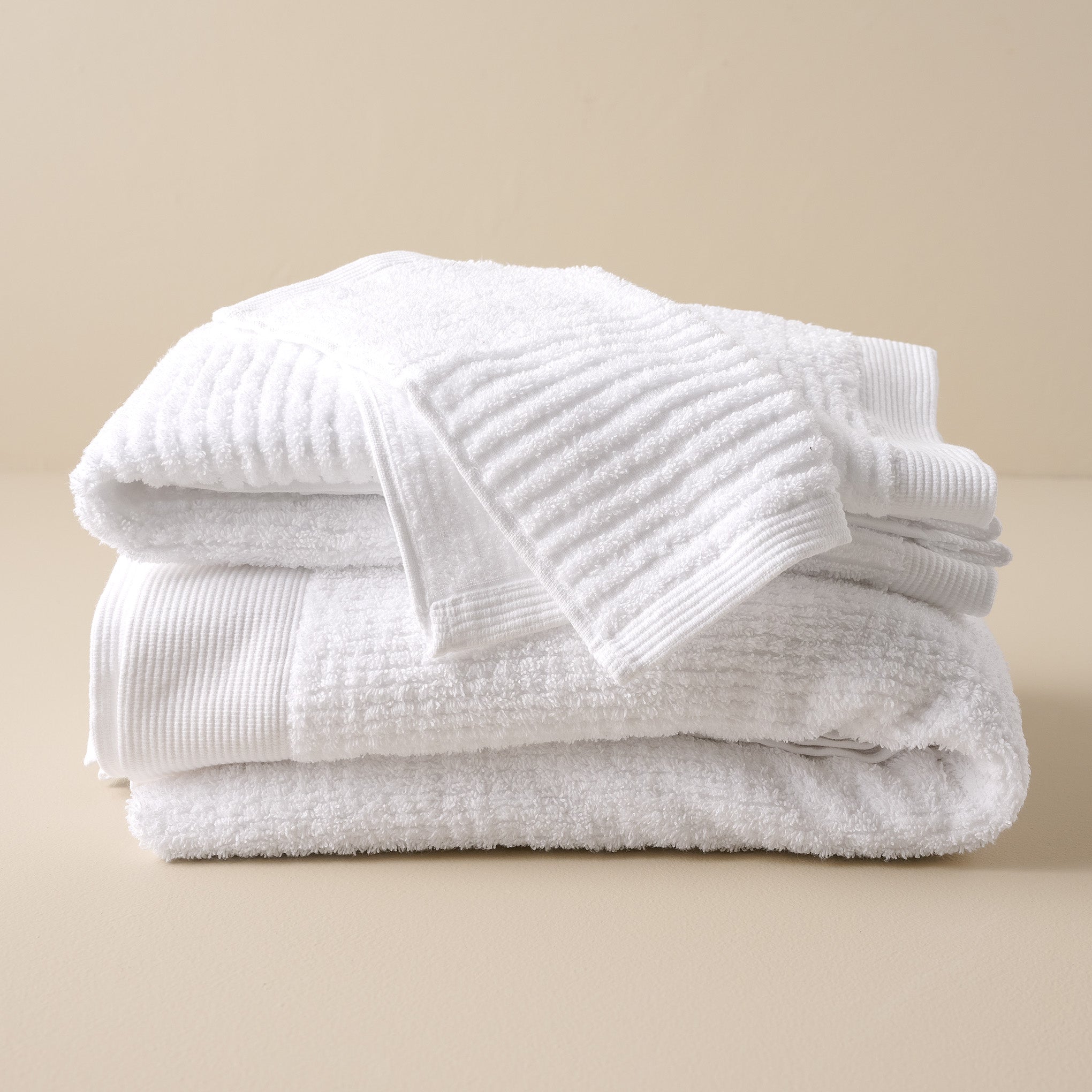 stacked White Textured bath towels and washcloth Items range from $12.00 to $42.00
