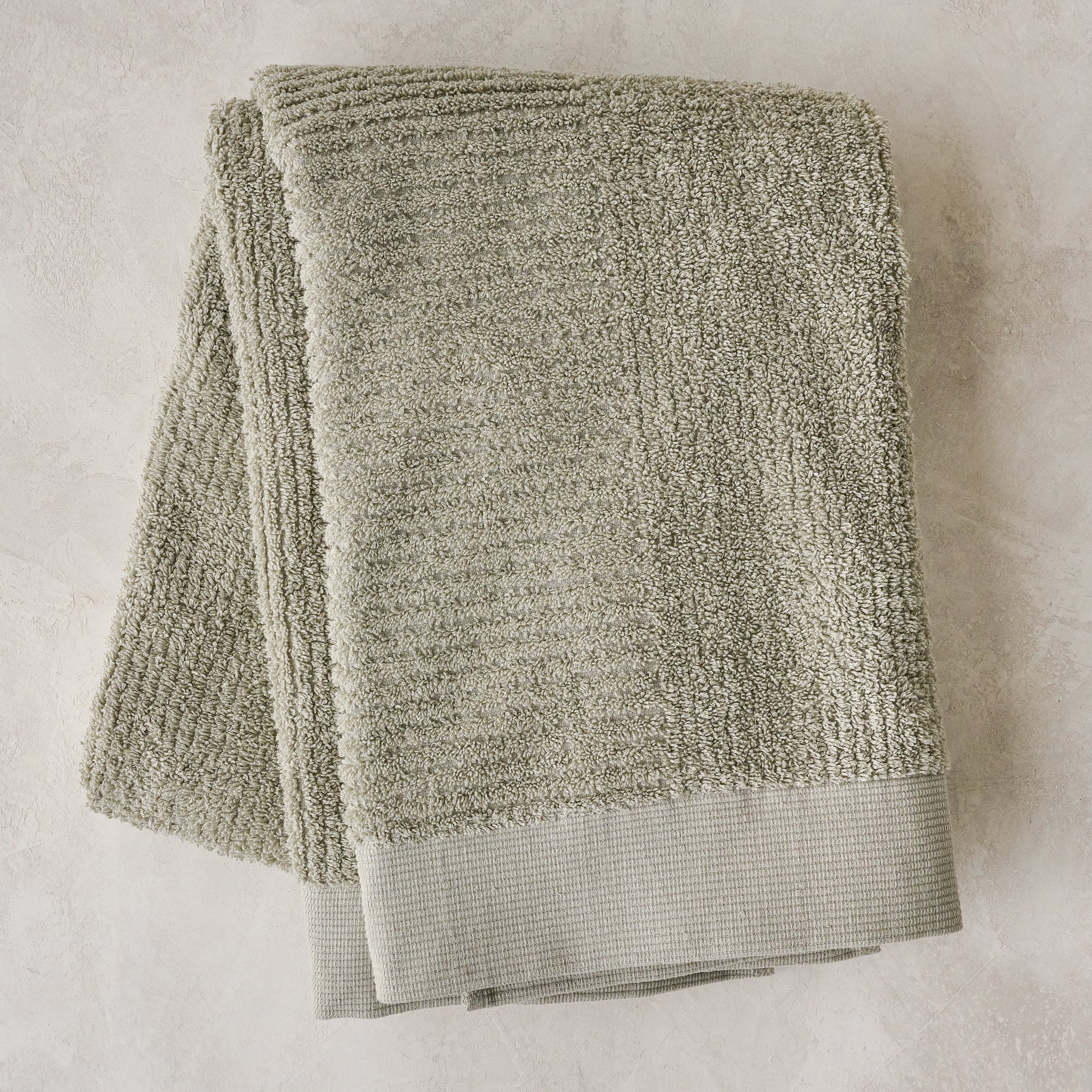 folded eucalyptus green textured bath towels