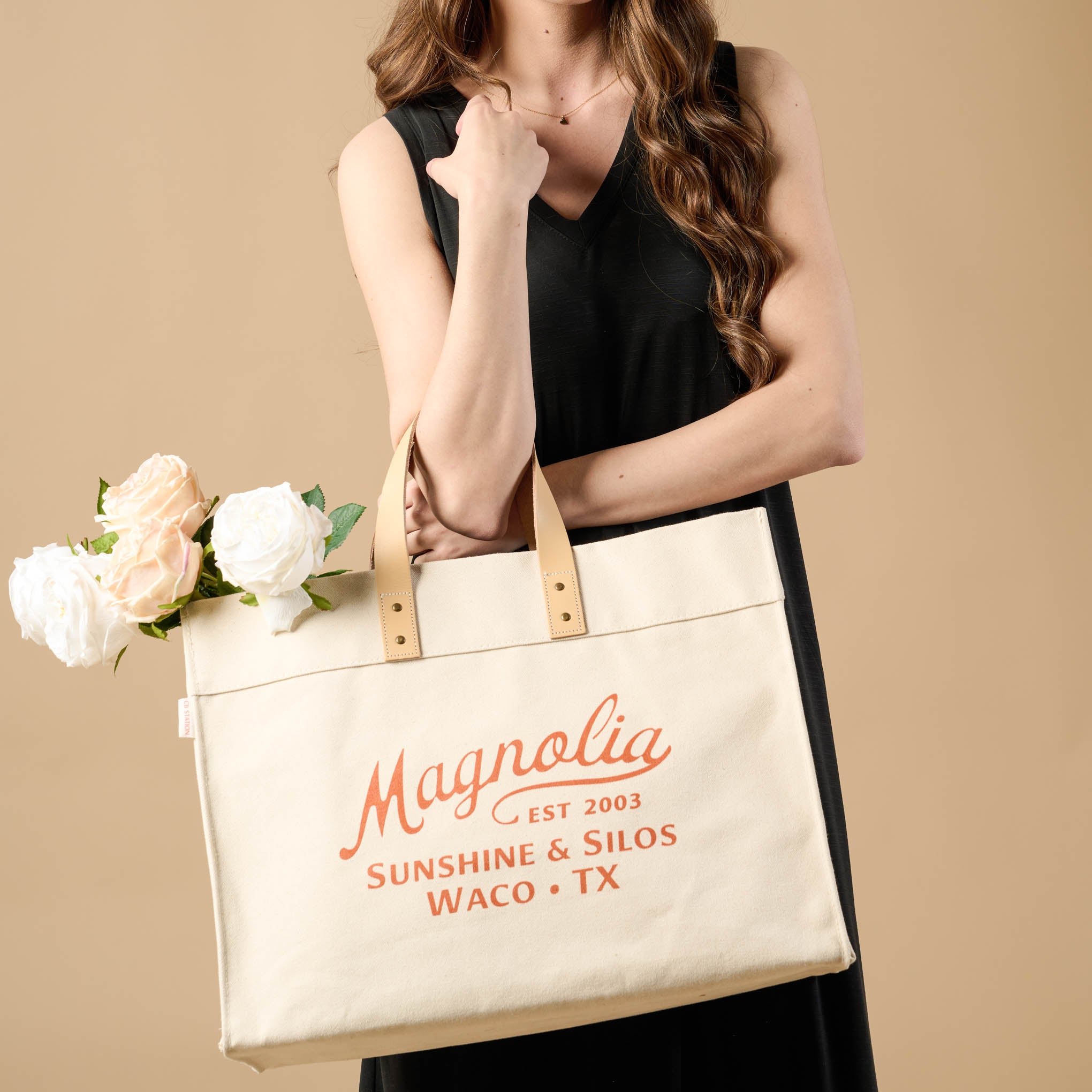 Magnolia Cora Script Large Canvas Tote with florals sticking out of the bag