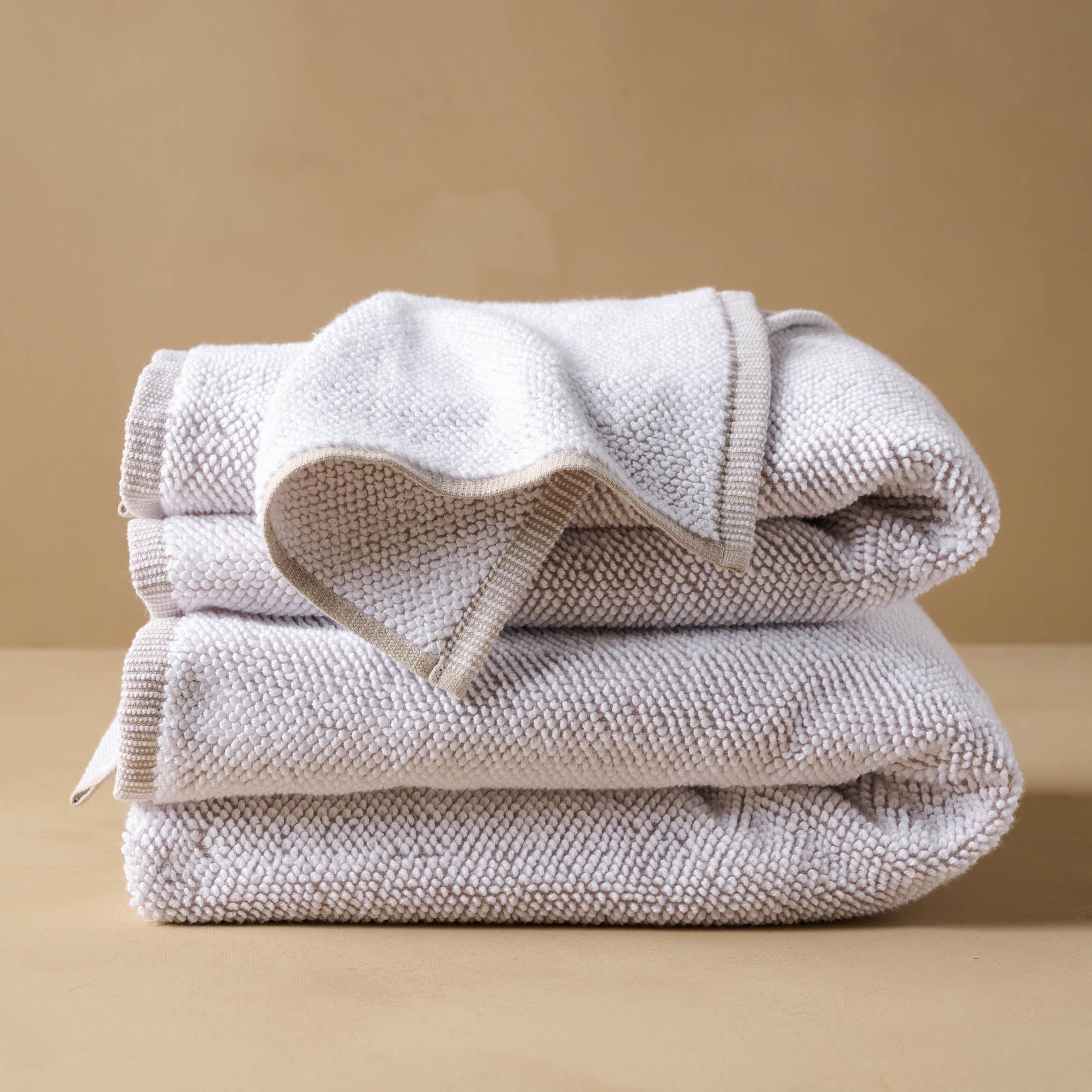 Linen Assisi Textured Towel folded with wash cloth draped on top Items range from $14.00 to $40.00