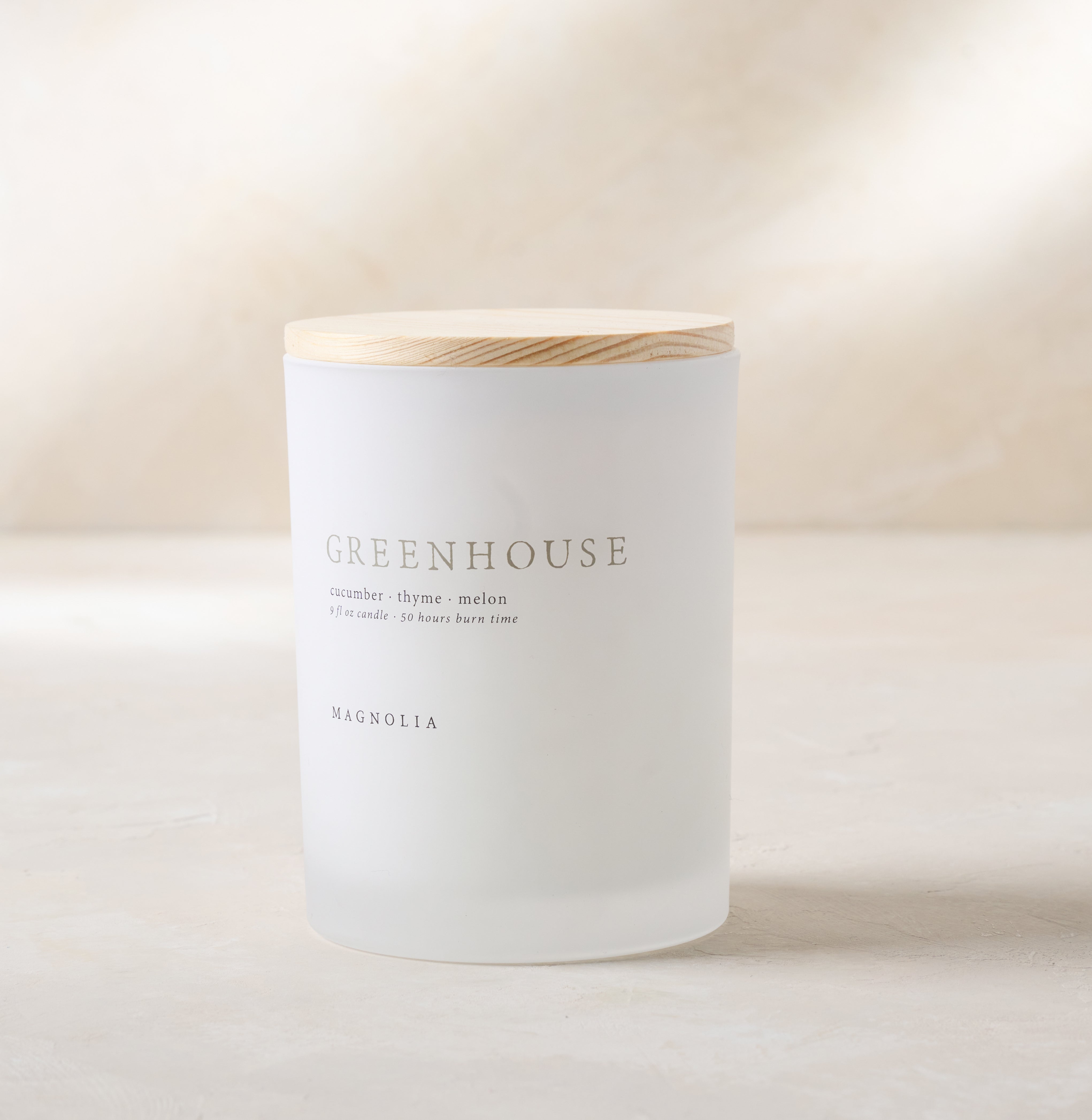 magnolia greenhouse candle with wood lid notes scents of cucumber thyme and melon$30.00