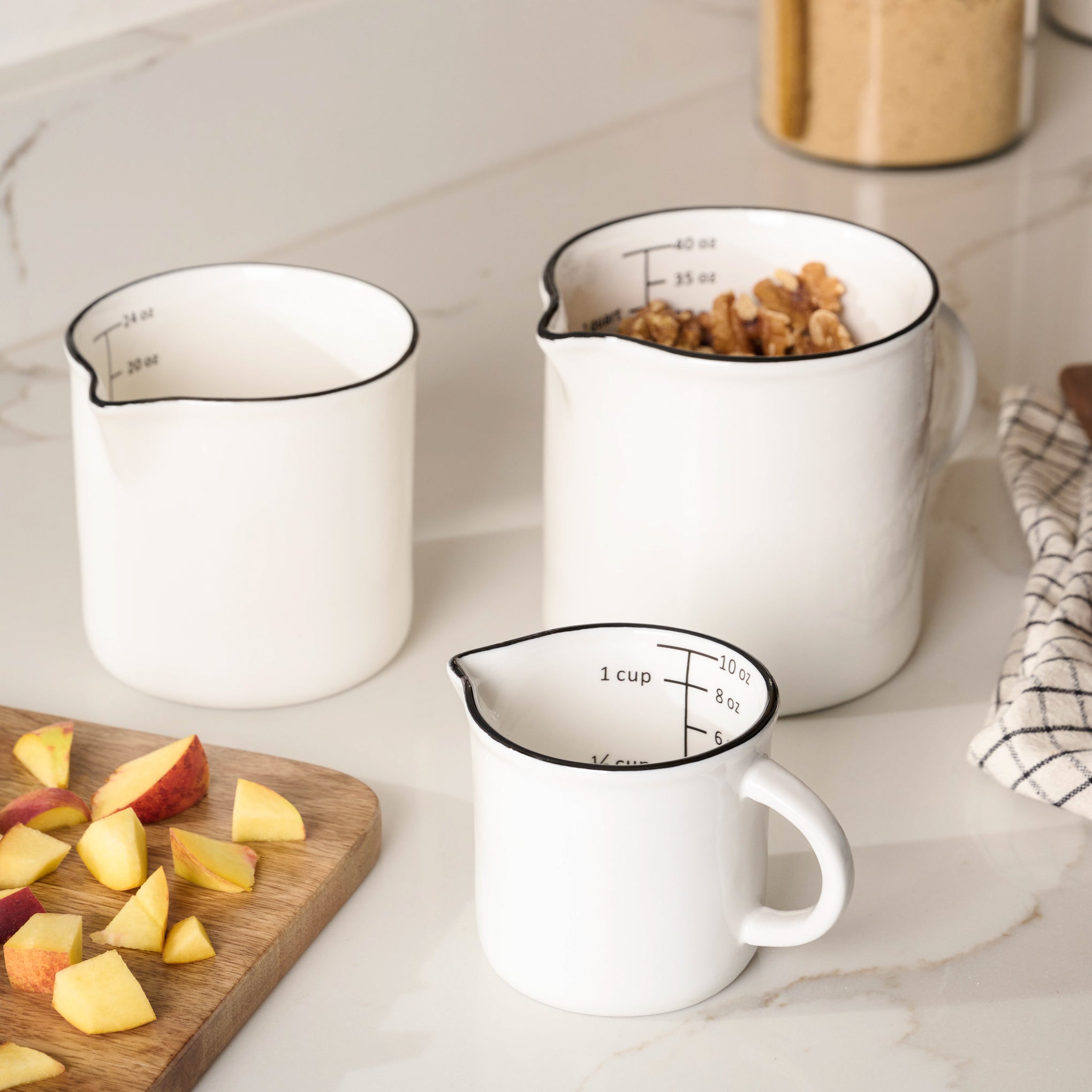 Magnolia Black Rim Measuring Pitcher in three sizes on countertop Items range from $10.00 to $16.00