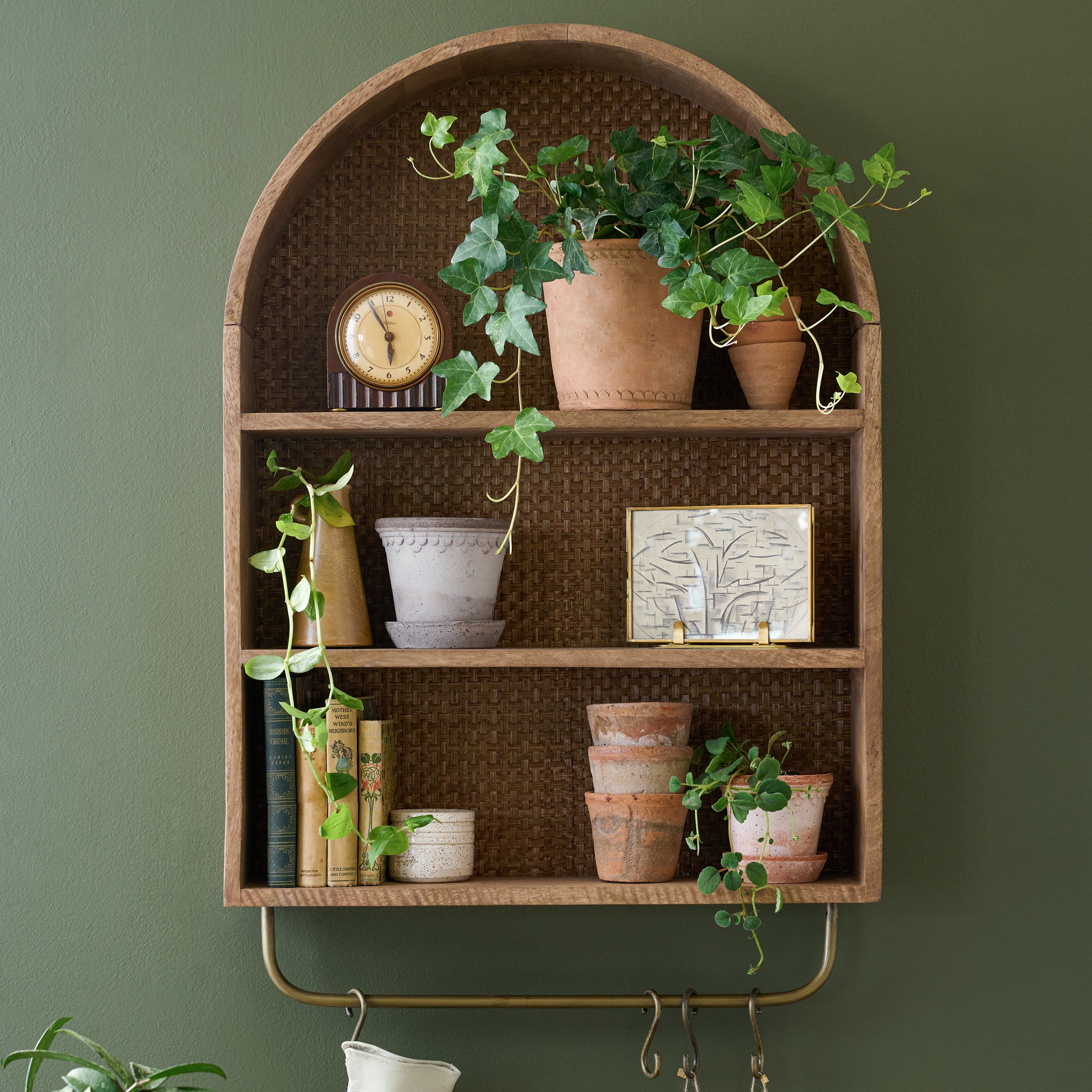 Belmar Arched Woven Wall Shelf with plants and pots and a clock on shelves$288.00