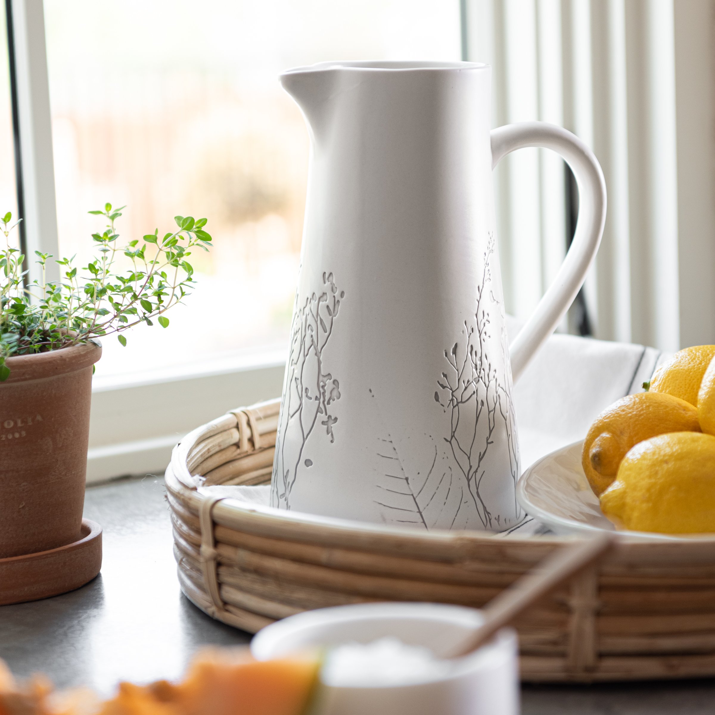 tapered white ceramic pitcher with embossed pressed floral print detail$26.00