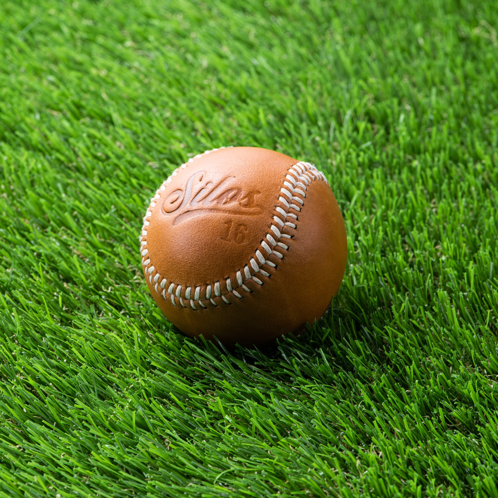 tan leather baseball with silos baseball logo and magnolia logo on the opposite side