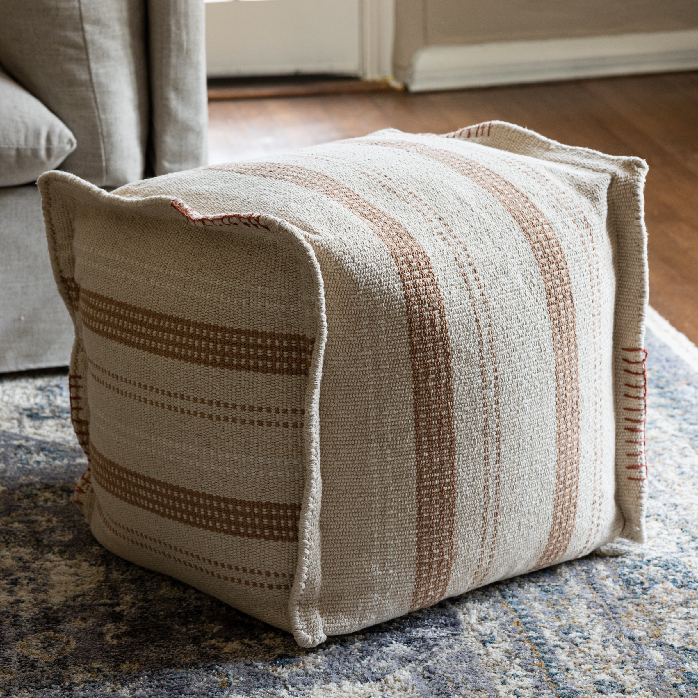 large pouf cushion with neutral striped stitching