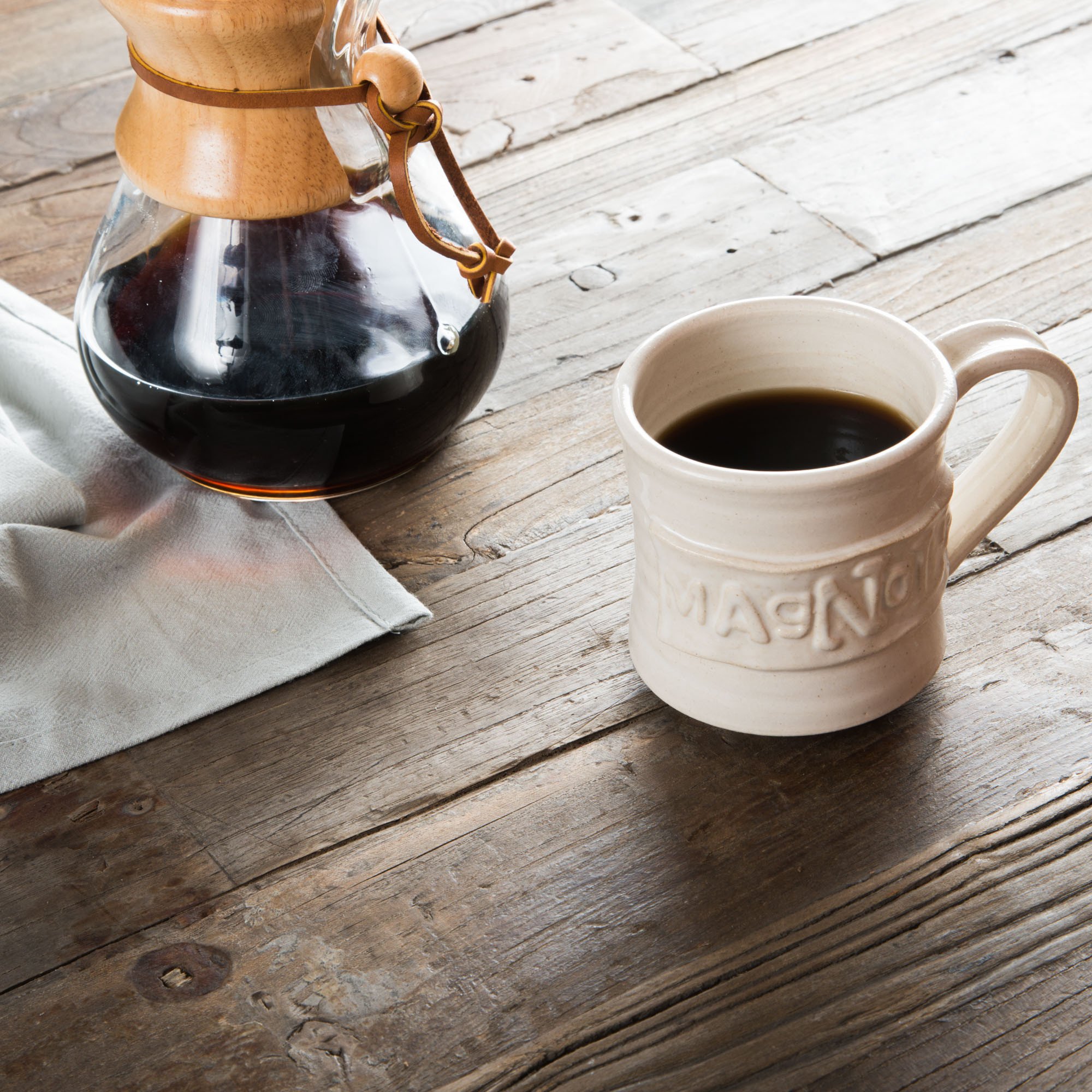 white handthrown ceramic mug with original Magnolia logo embossed on side