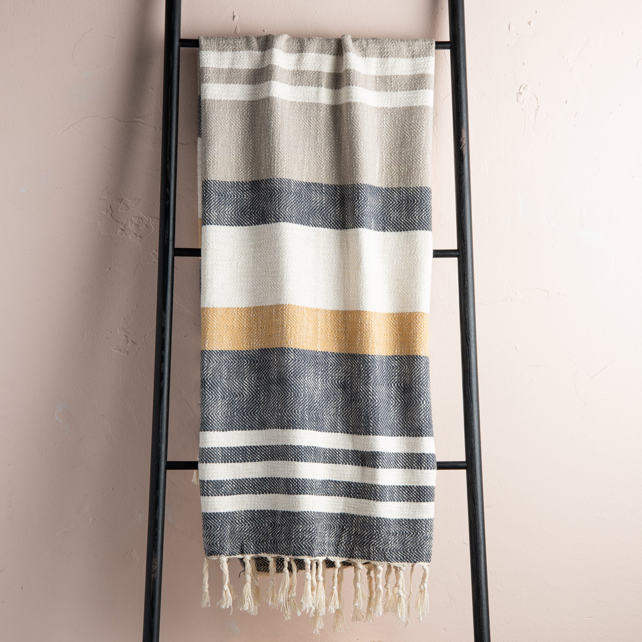 charcoal, cream, beige, and mustard striped throw blanket with beige tassel fringe