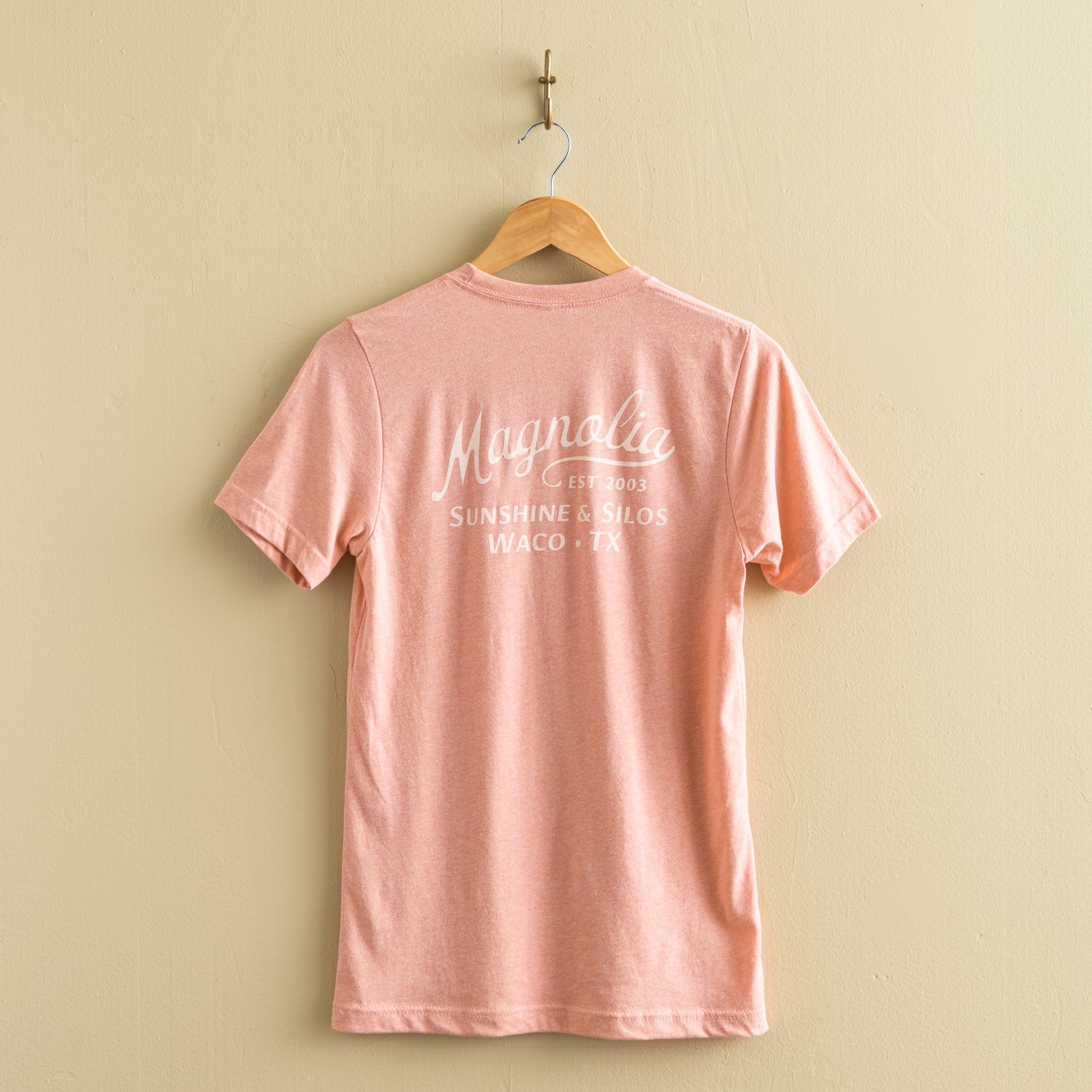 pink-coral t-shirt with "magnolia est 2003" in a cursive script font$32.00