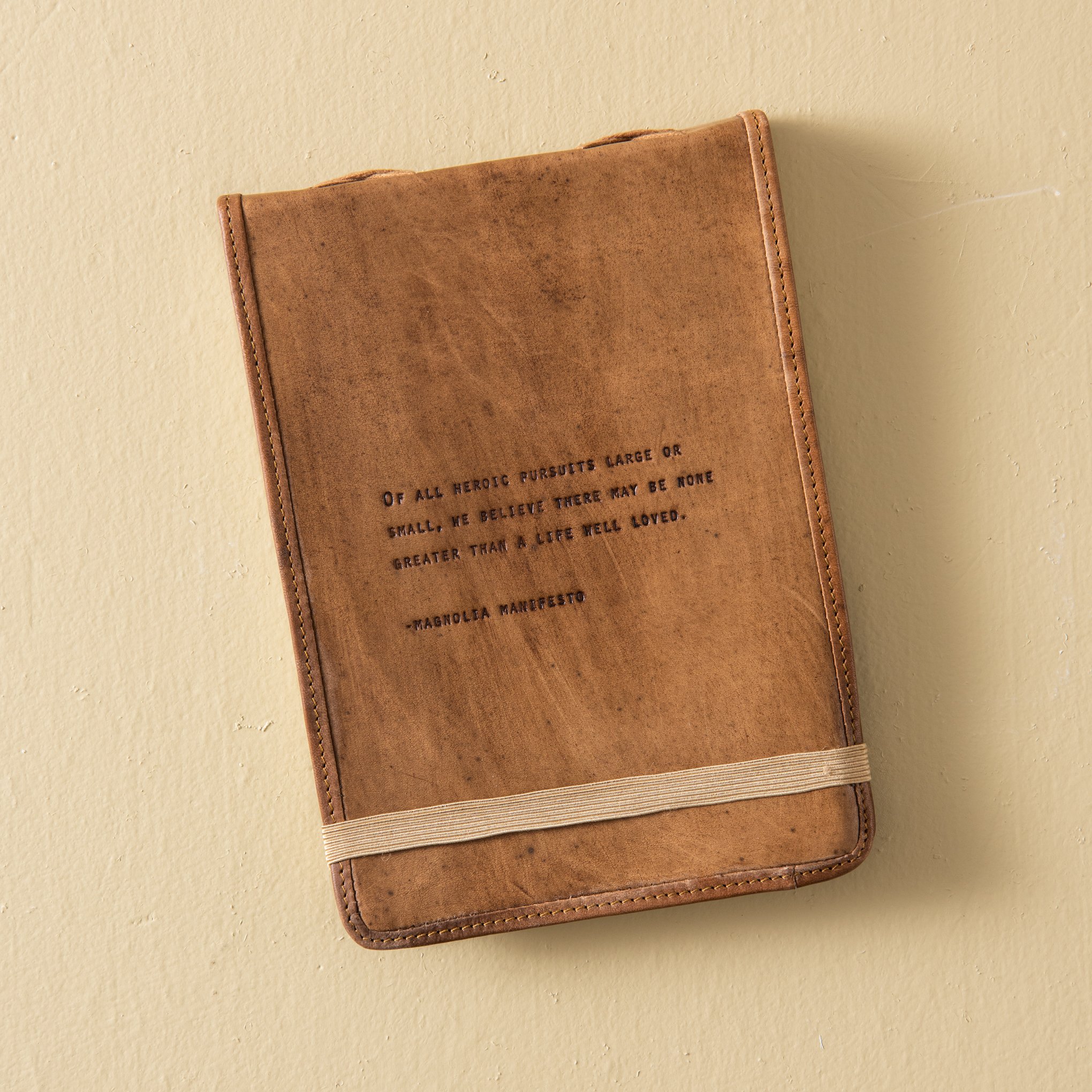 leather journal with line from Mangolia Manifesto embossed on cover