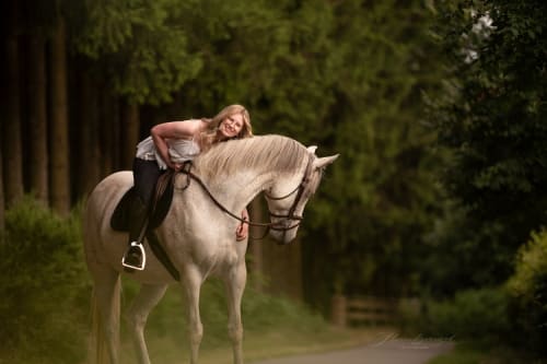 /_vercel/image?url=/Girl+sitting+on+the+white+horse+in+the+forest.&w=1536&q=100
