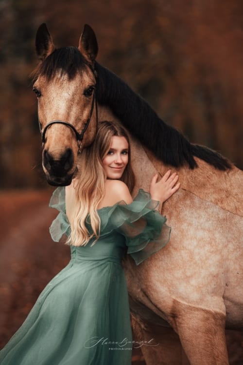 /_vercel/image?url=/Girl+with+blond+hair+in+long+green+dress+with+horse+in+autumn.&w=1536&q=100
