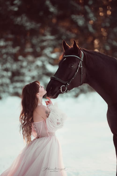 /_vercel/image?url=/Girl+in+dress+looking+at+her+horse+with+snow.&w=1536&q=100