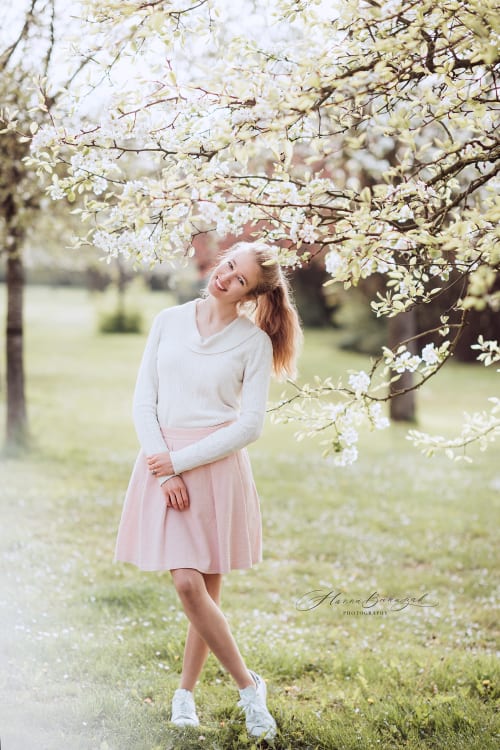 /_vercel/image?url=/Blond+girl+in+the+creamy+blouse+and+skirt+is+next+to+the+blossoming+tree&w=1536&q=100