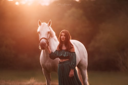 /_vercel/image?url=/Girl+in+long+green+dress+with+horse+on+the+meadow+during+summer+sunset.&w=1536&q=100