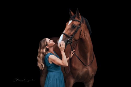 /_vercel/image?url=/Femme+en+robe+bleu++avec+le+cheval+sur+le+fond+noir.&w=1536&q=100