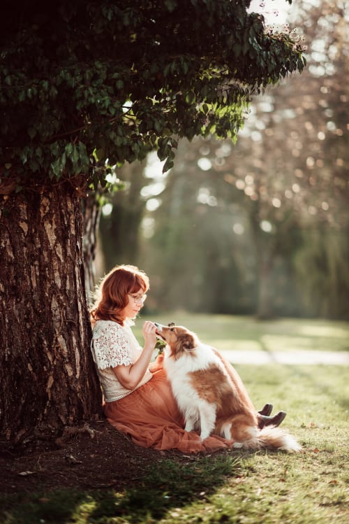/_vercel/image?url=/Women+with+her+dog+friend+are+leaning+on+the+tree.&w=1536&q=100