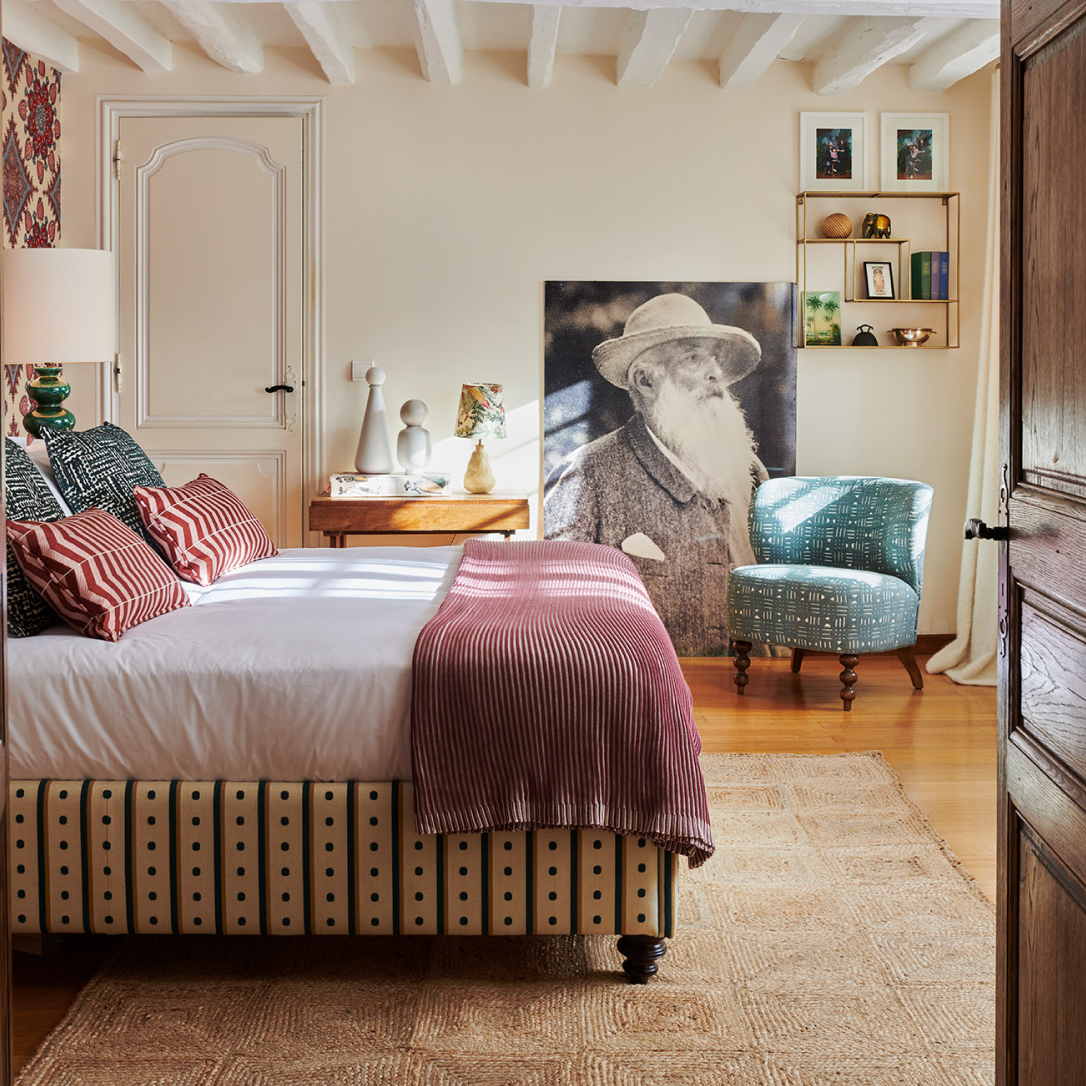 A bedroom with many soft furnishings and other decorations.