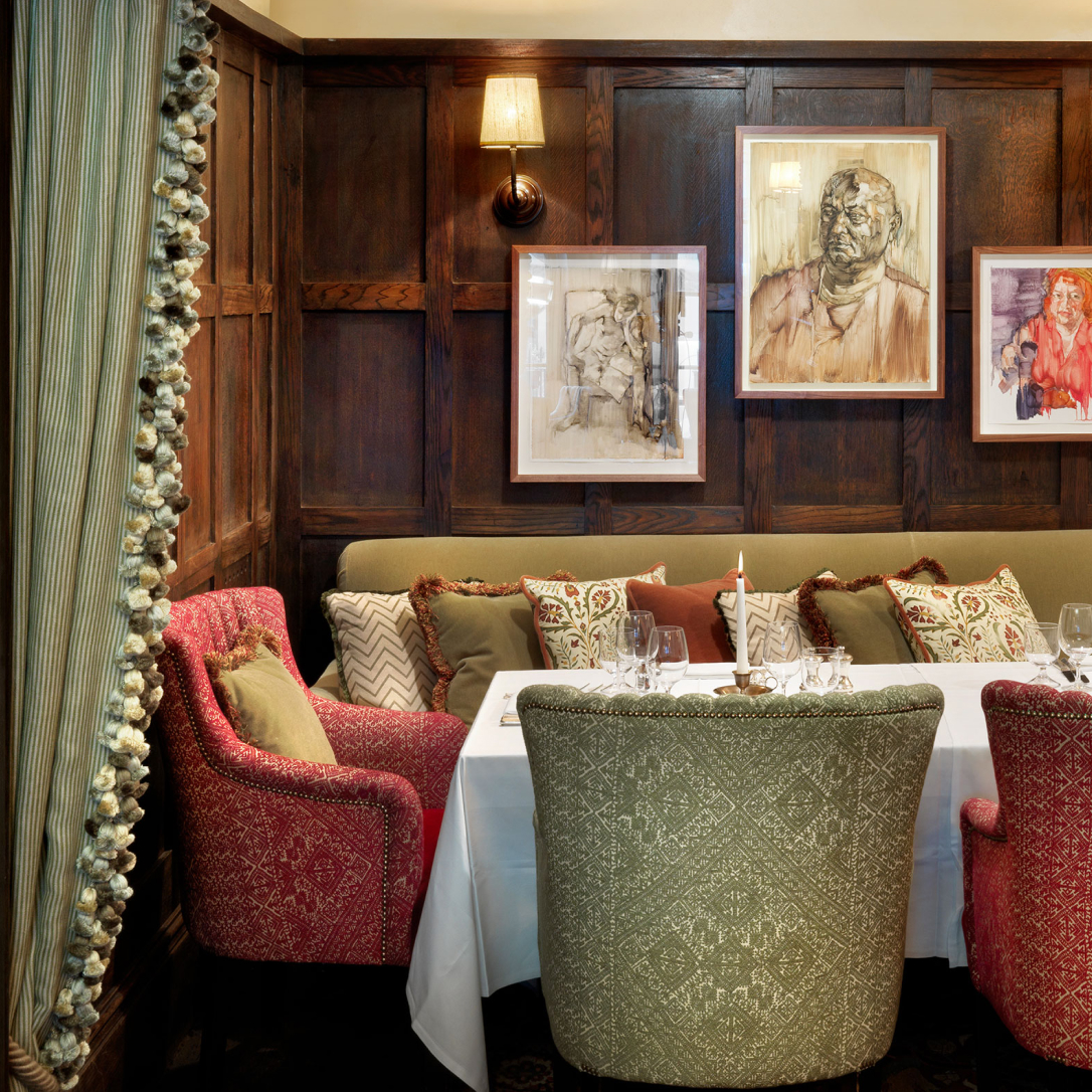 A cosy wood pannelled room with a table laid out for dinner.