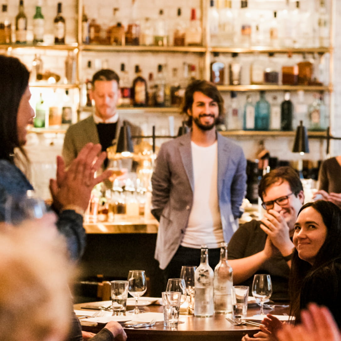 Diners applaud in a dining room.