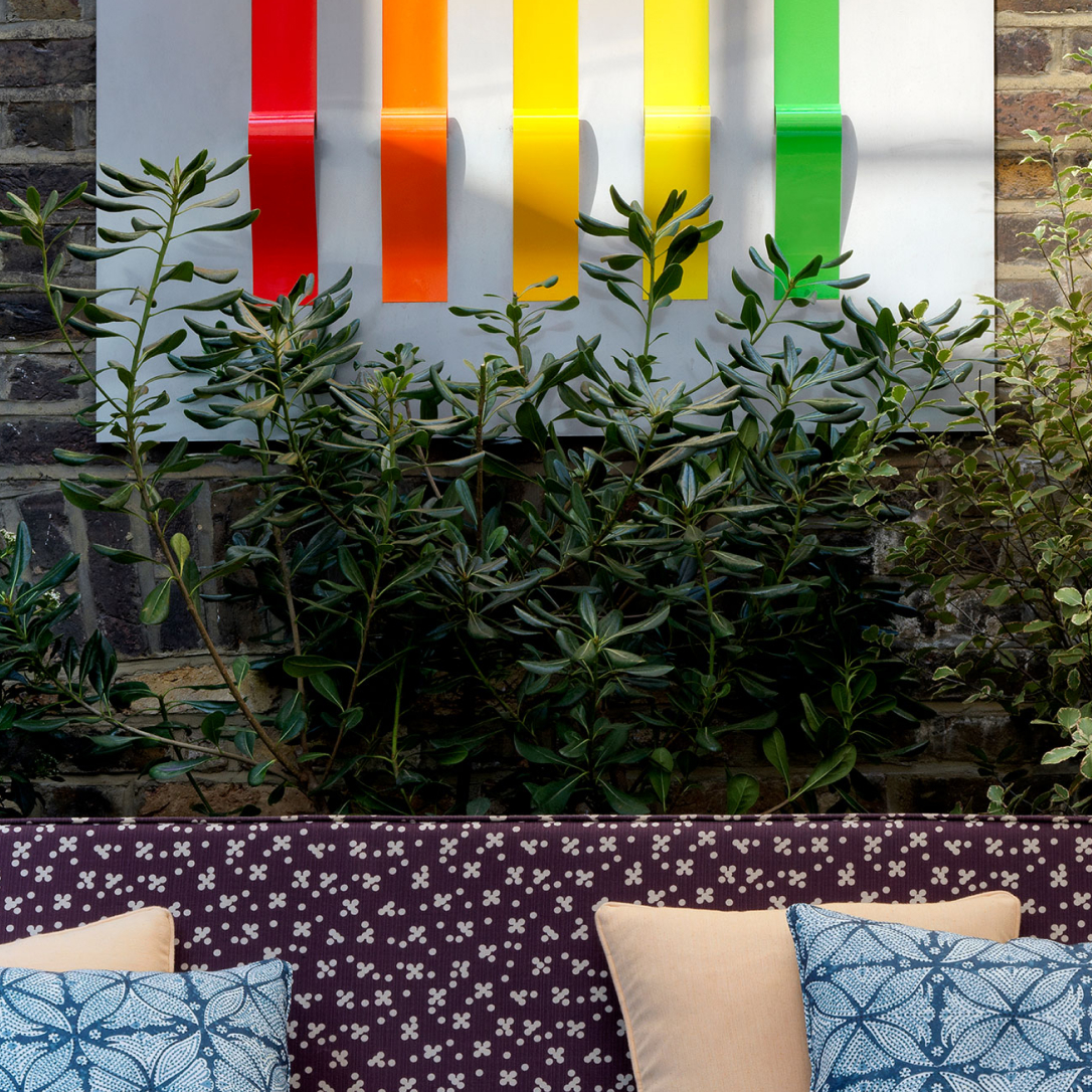 An outdoor seating area with a colourful artwork on the wall.