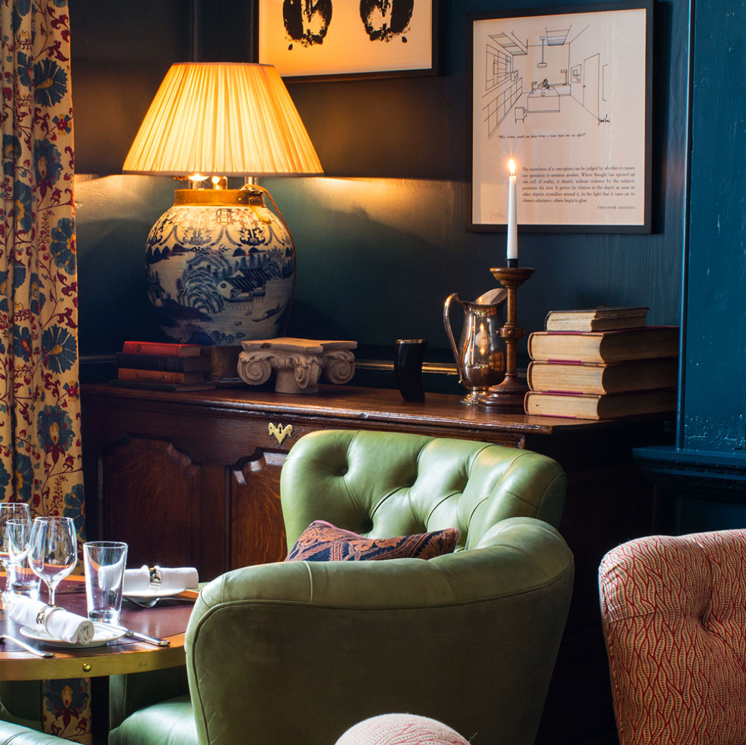 A table with green chairs around it in a blue room.