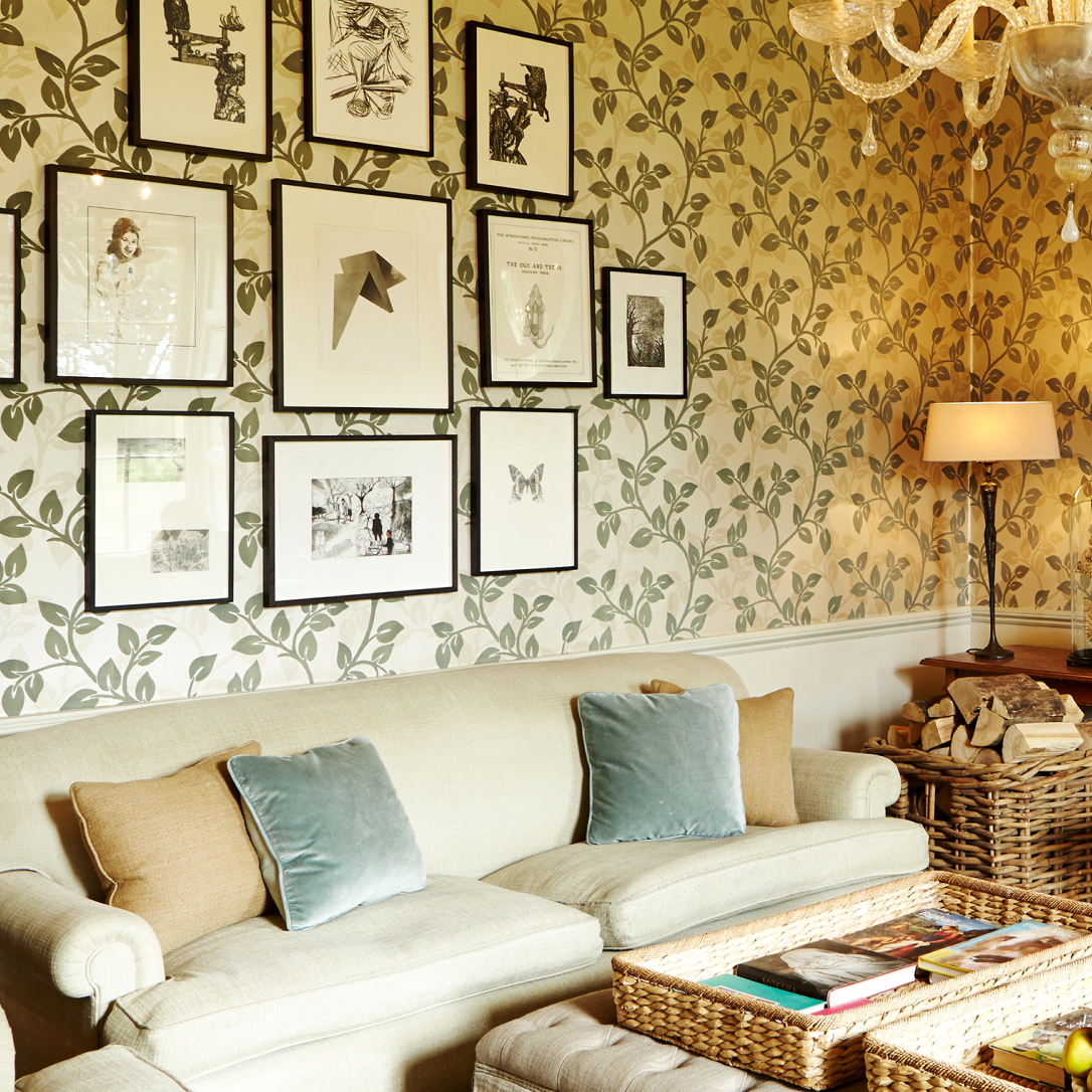 A small lounge area with a sofa and artworks on the walls.