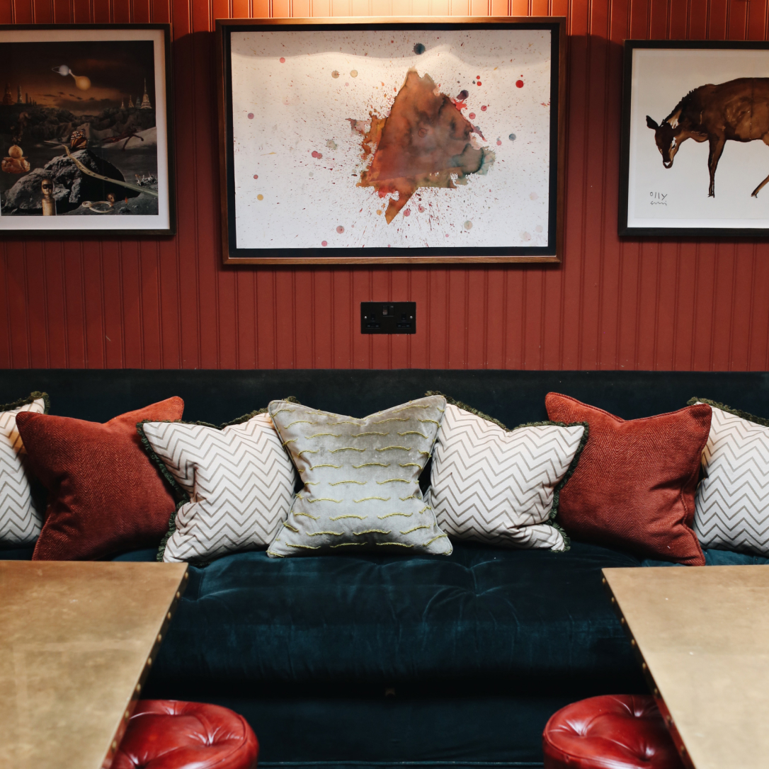 A cosy space with a table, seating and cushions.