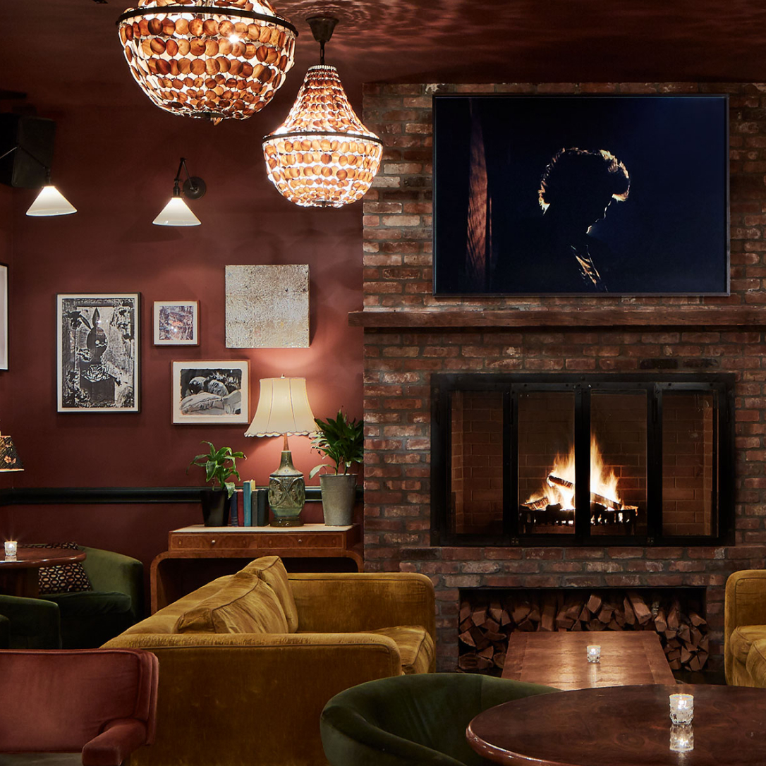 A cosy warmly lit space with a burning fire.