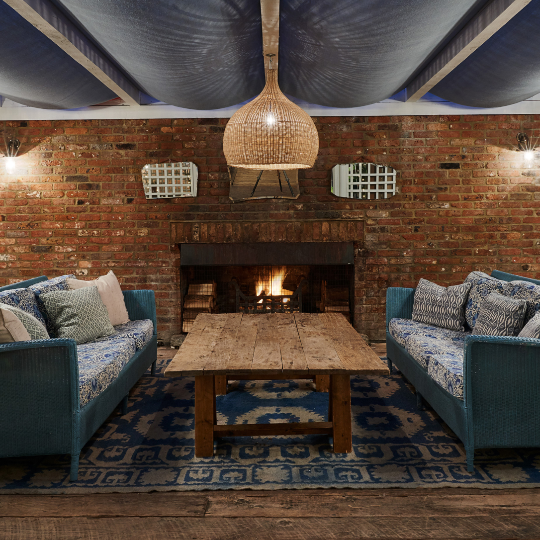 Two sofas and a coffee table by a burning fire.