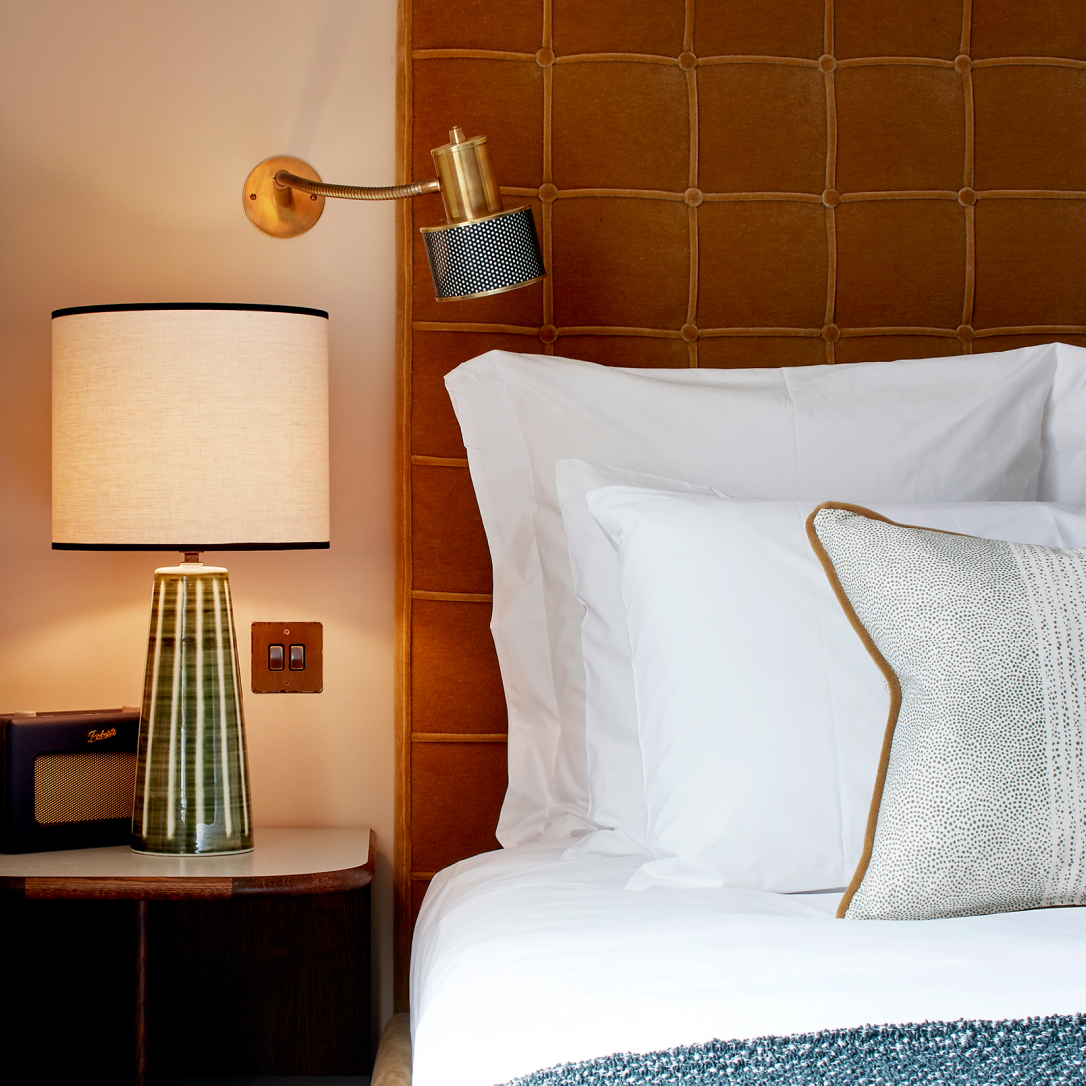 The corner of a bed and side table.