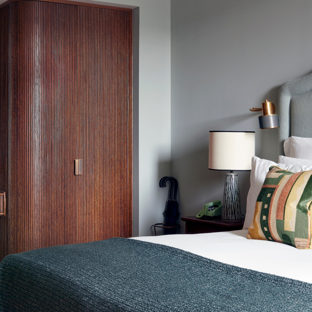 The corner of a bedroom with a bed and a wardrobe.