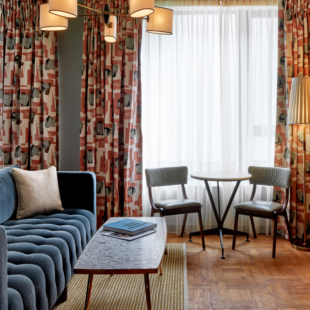 A bedroom with a sofa and table and chairs.