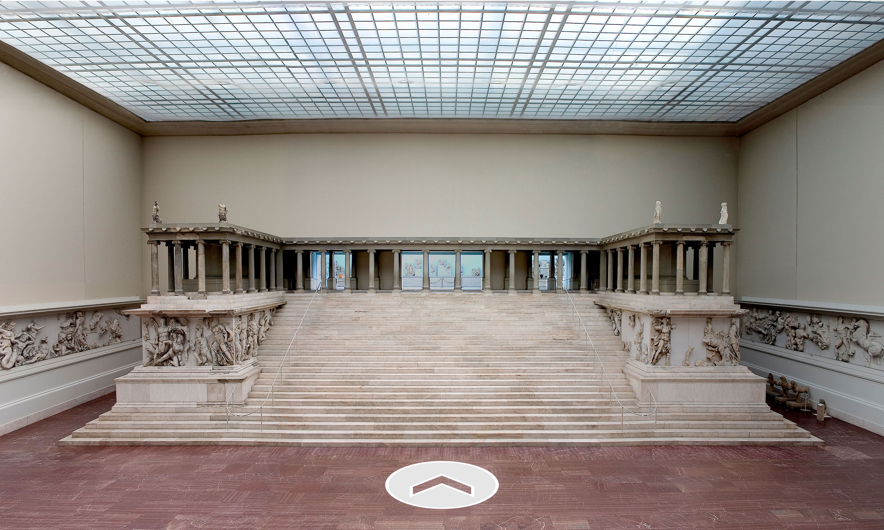 A greek ruin in a large museum space.