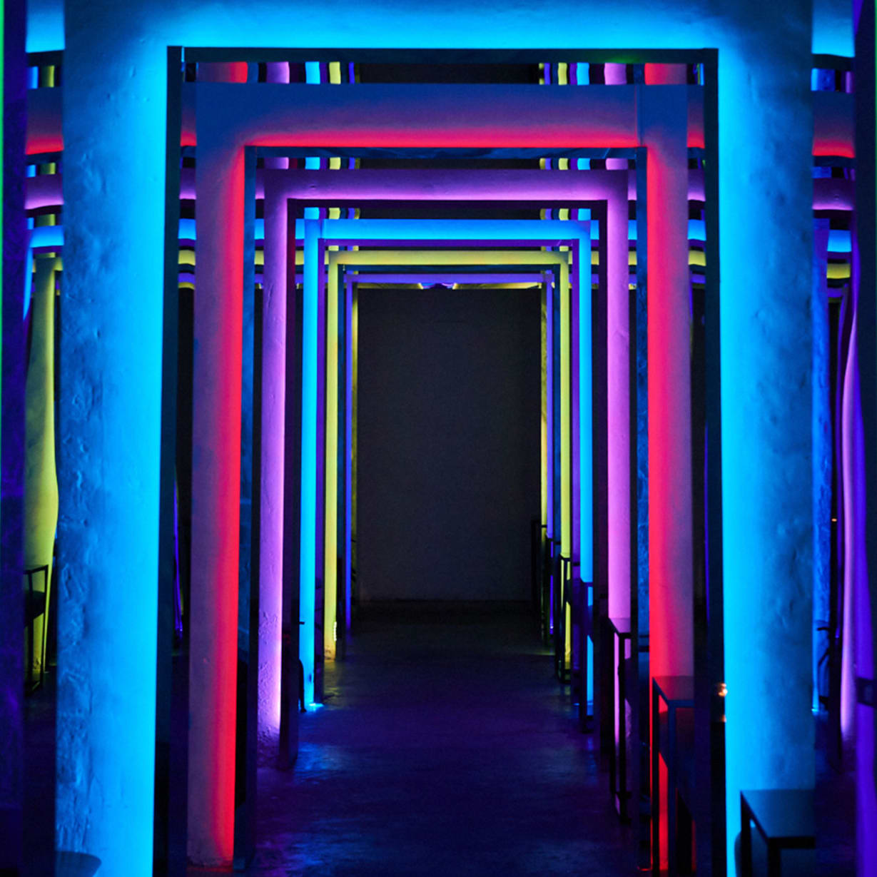 a tunnel lit with multiple neon colours