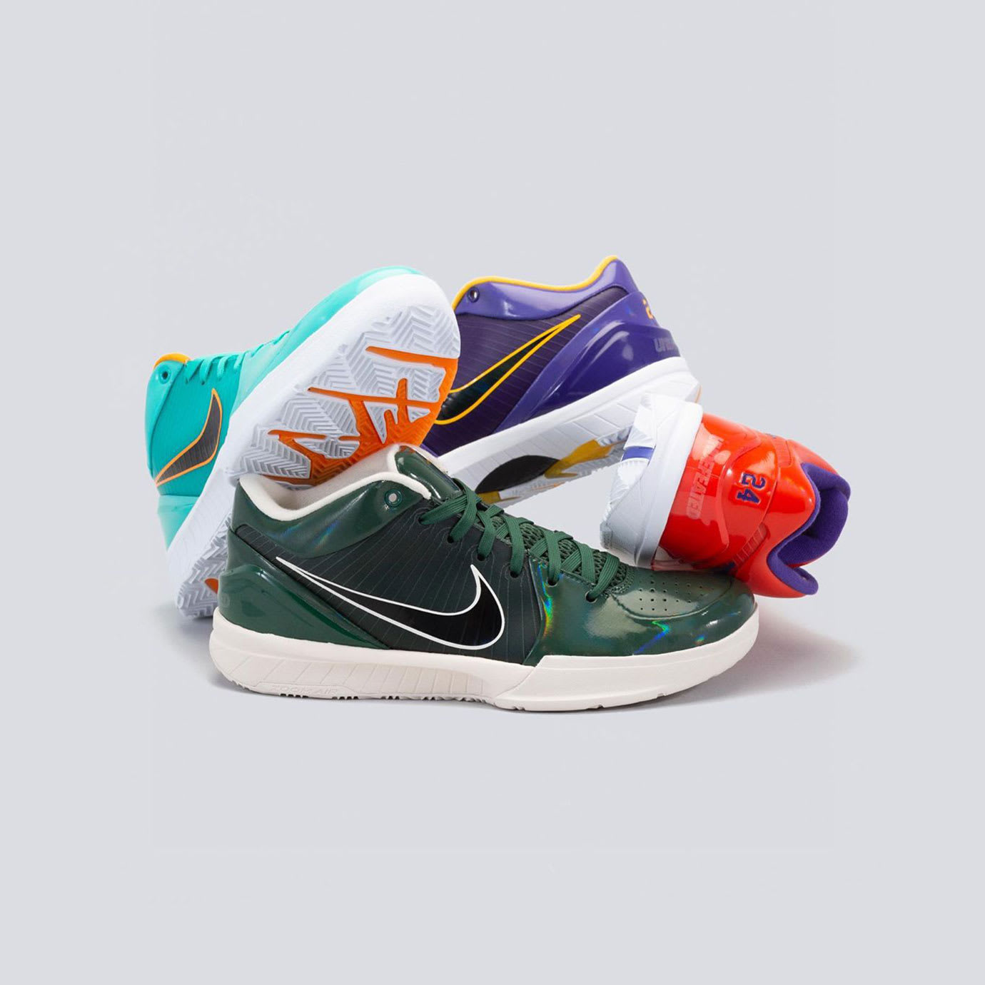 Trainers in a pile on a grey background.