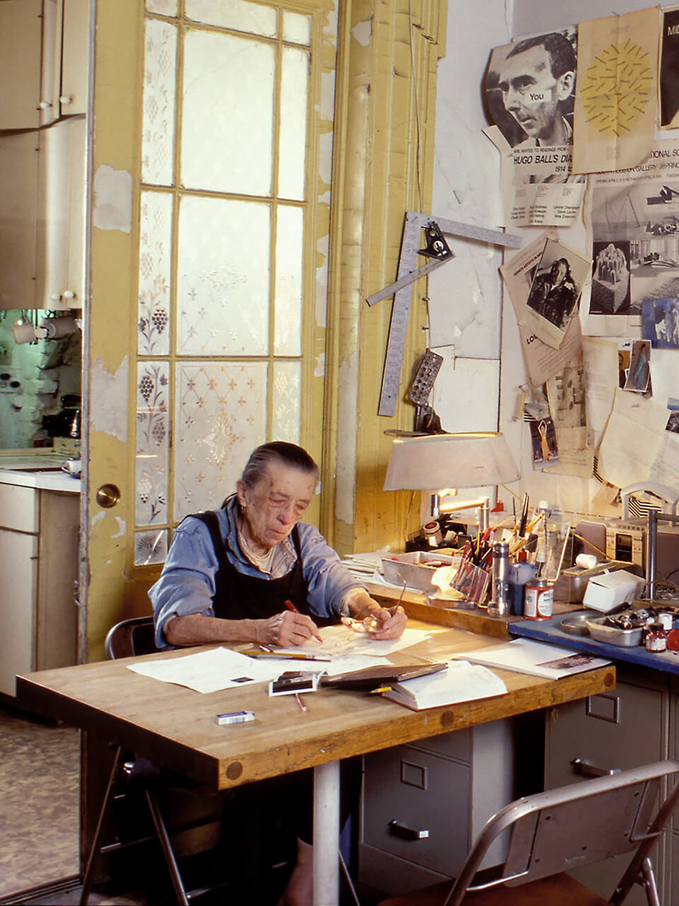 An old lady drawing in her studio.