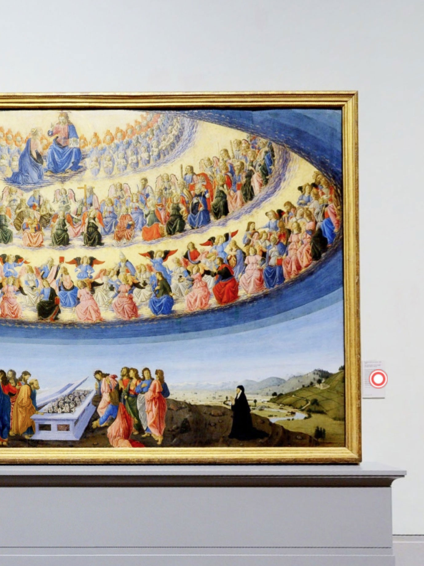 A painting on a wall with a clickable red icon next to it.