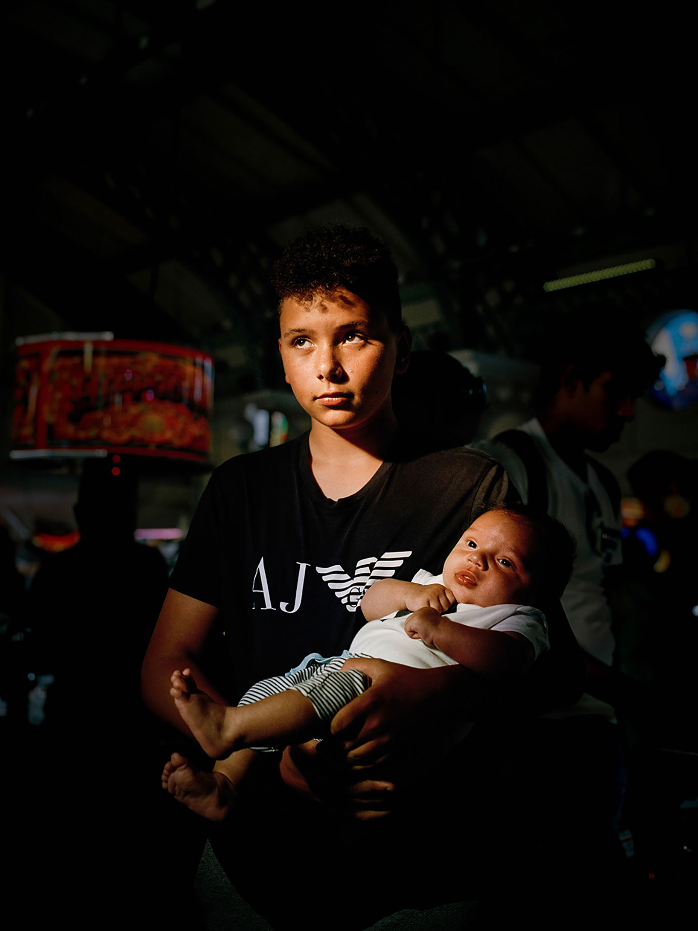 A young boy holds a baby.